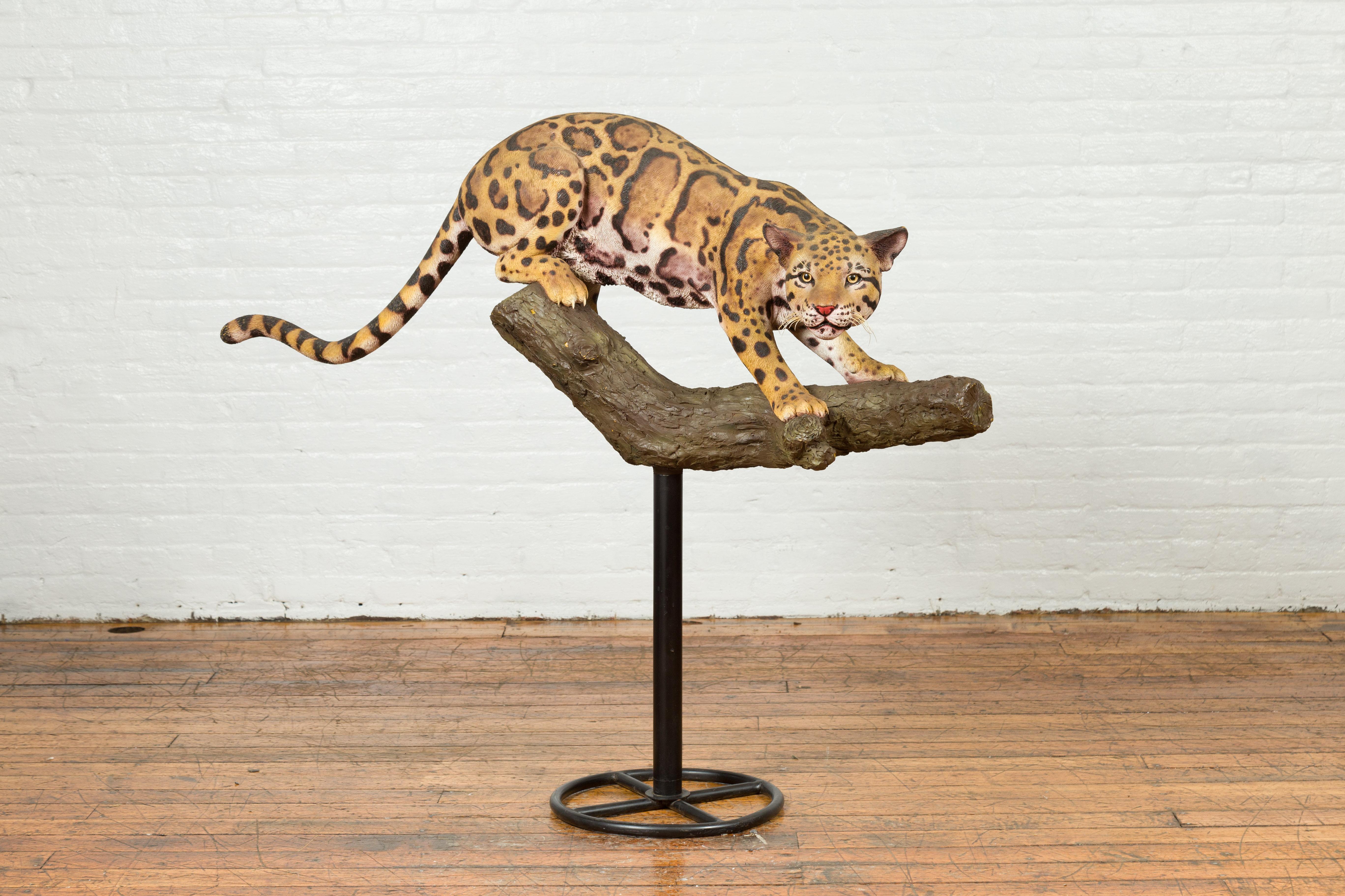 A contemporary fiberglass leopard sculpture mounted on a tree base. Originally designed as a prototype for a collection of fiberglass statues, this sculpture attracts immediately our attention with its striking subject and great realism. The leopard