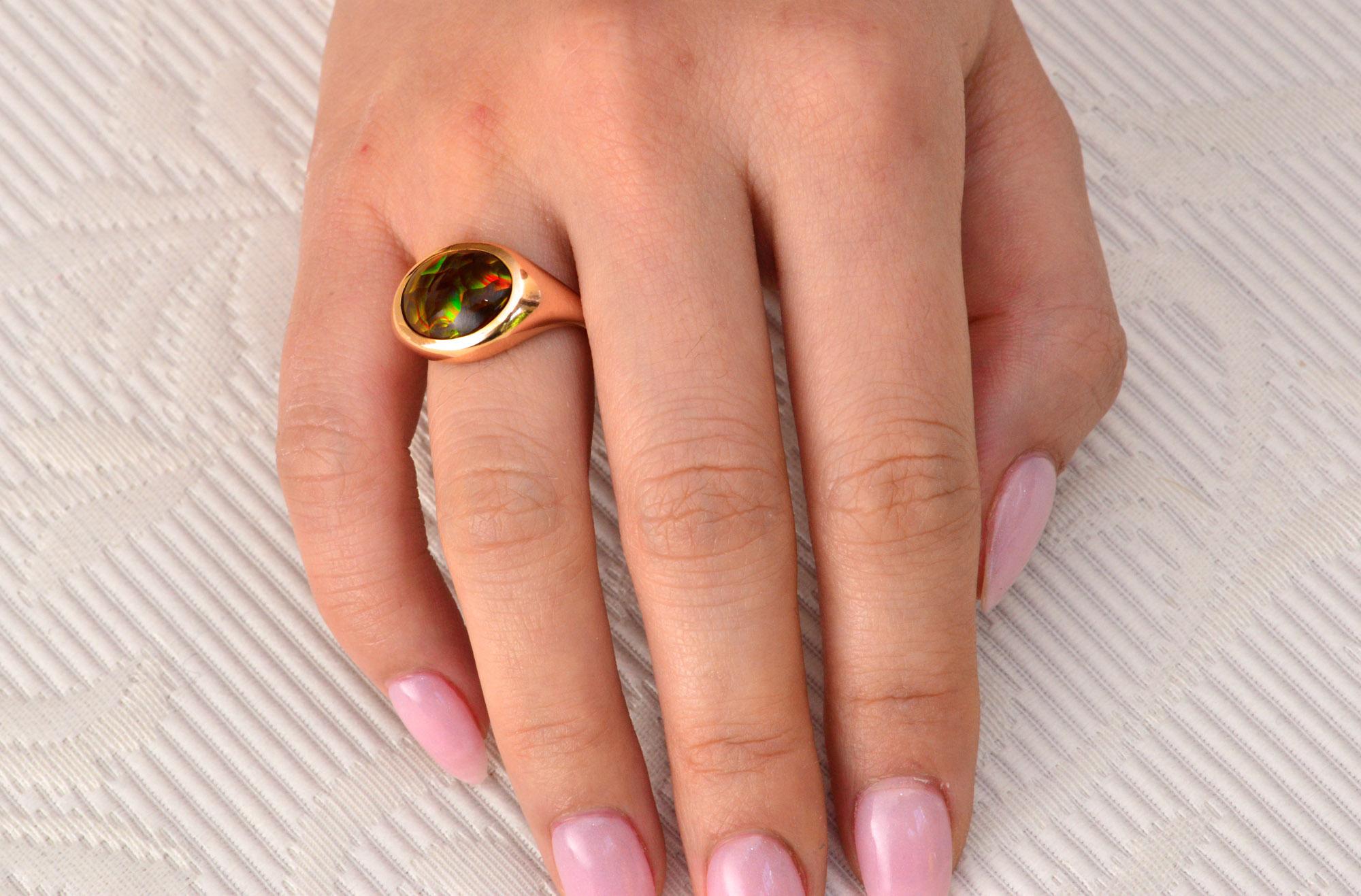 This Contemporary hand crafted ring is set with a domed Fire Agate from Slaughter Mountains in Arizona. The Fire Opal has very similar characteristics to an Australian Boulder Opal. A very interesting ring.