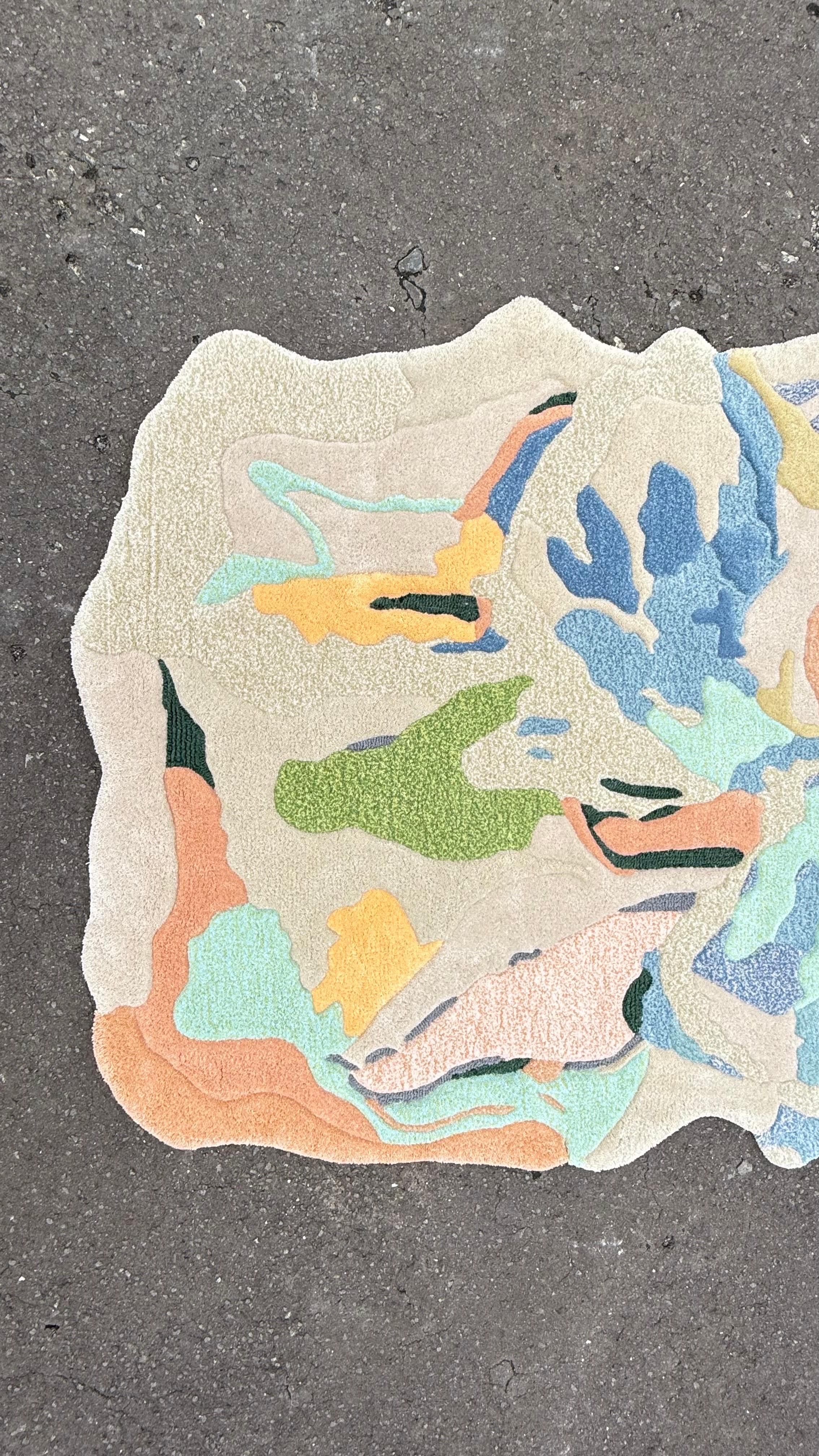 This contemporary rug celebrates the beauty of nature through an abstract floral composition in soft yet vibrant pastel tones—peach, blue, green, yellow, and cream. The organic silhouette follows the movement of petals, giving the piece a sculptural