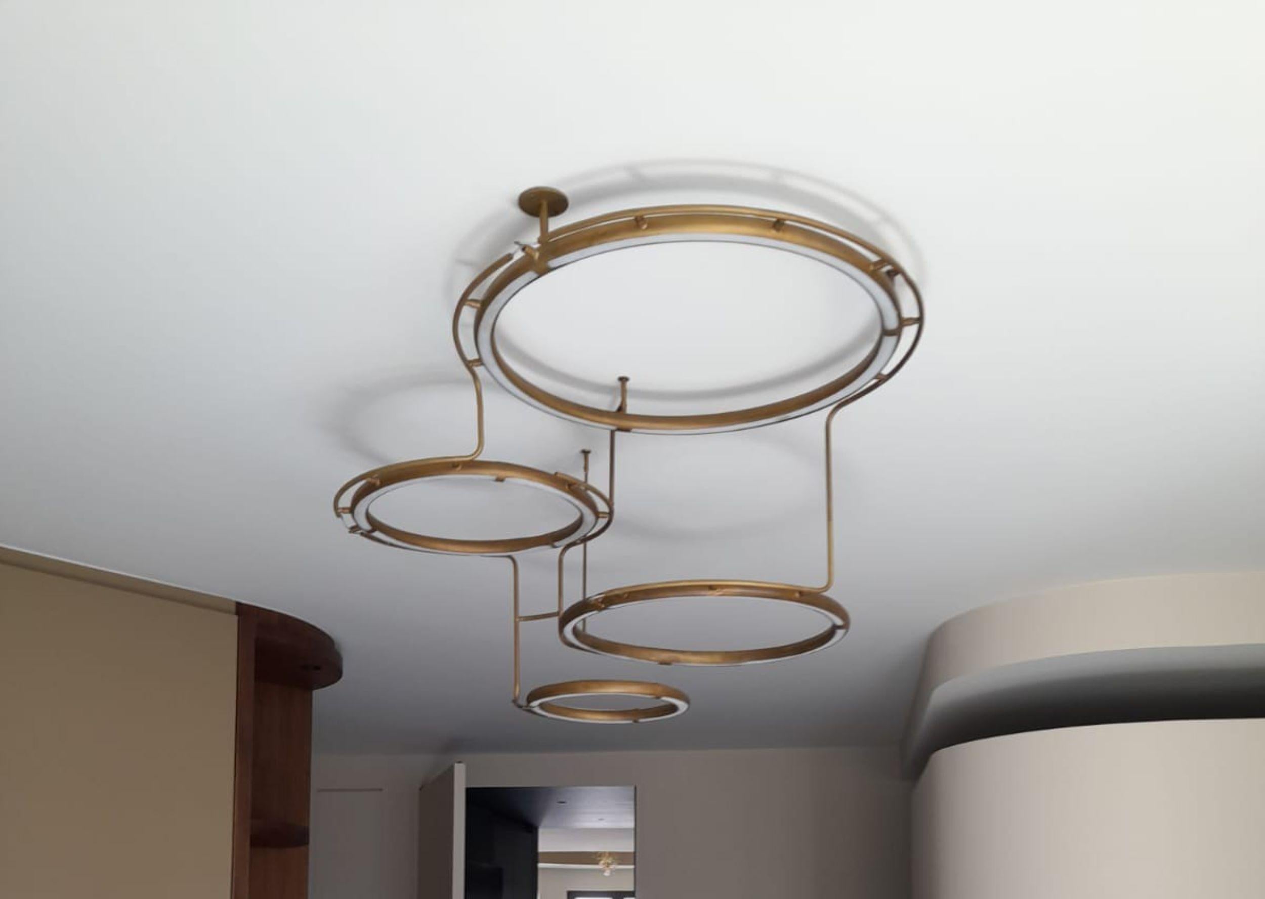 This pendant is a construction of 4 brass rings with flexible led tubes in the rings. The rings are connected to each other and hang over and next to each other. 
Measures: There is 1 ring of 51 cm, 1 ring of 41,5 cm, 1 ring of 35,5 cm and 1 ring of