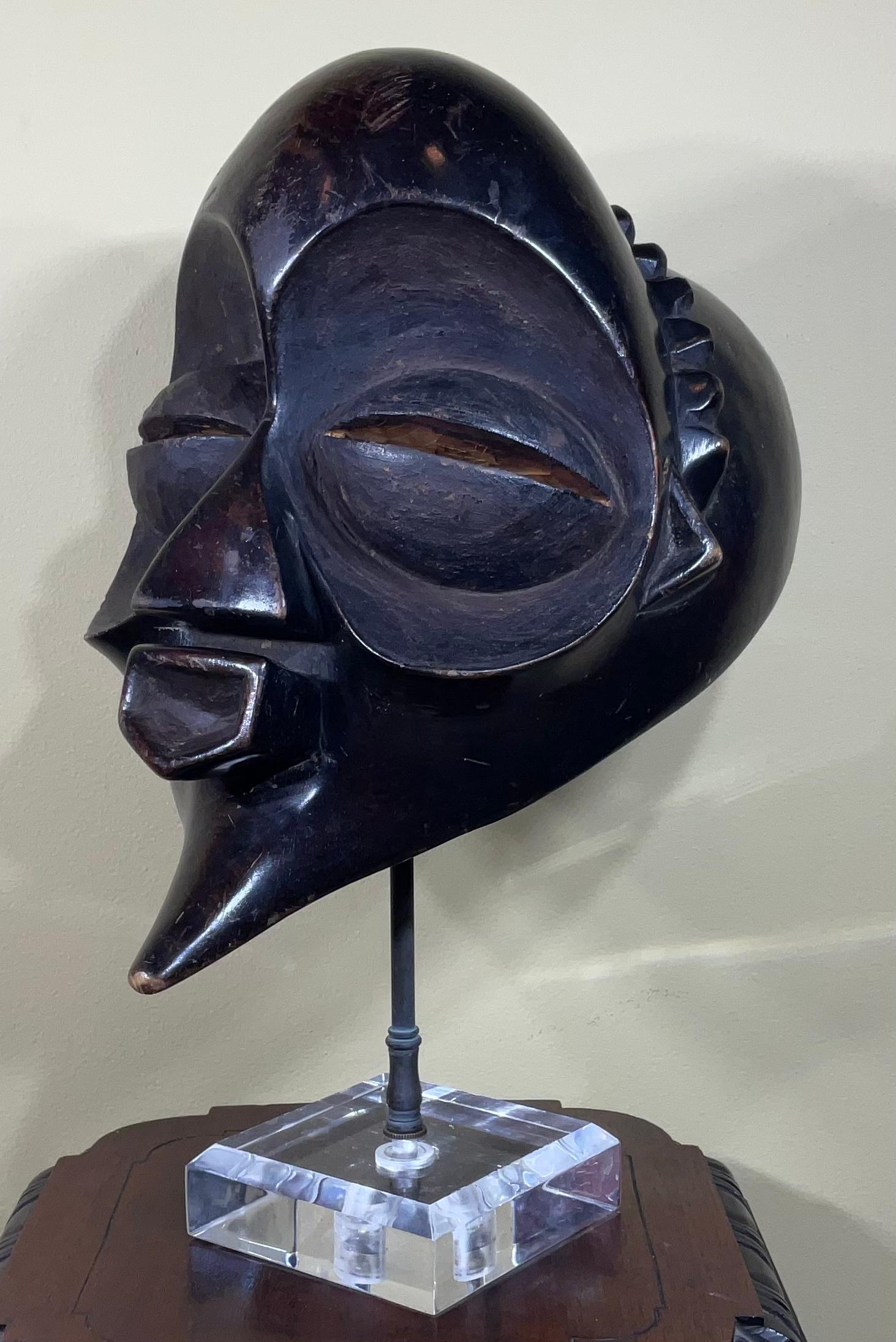 Exceptional hand carved wood mask with graphic elements, made of a single piece of wood and was made for decorative purposes. Very intriguing and mysterious face.
The mask in mounted on custom made lucite base.
Size without base is: 11”wide x