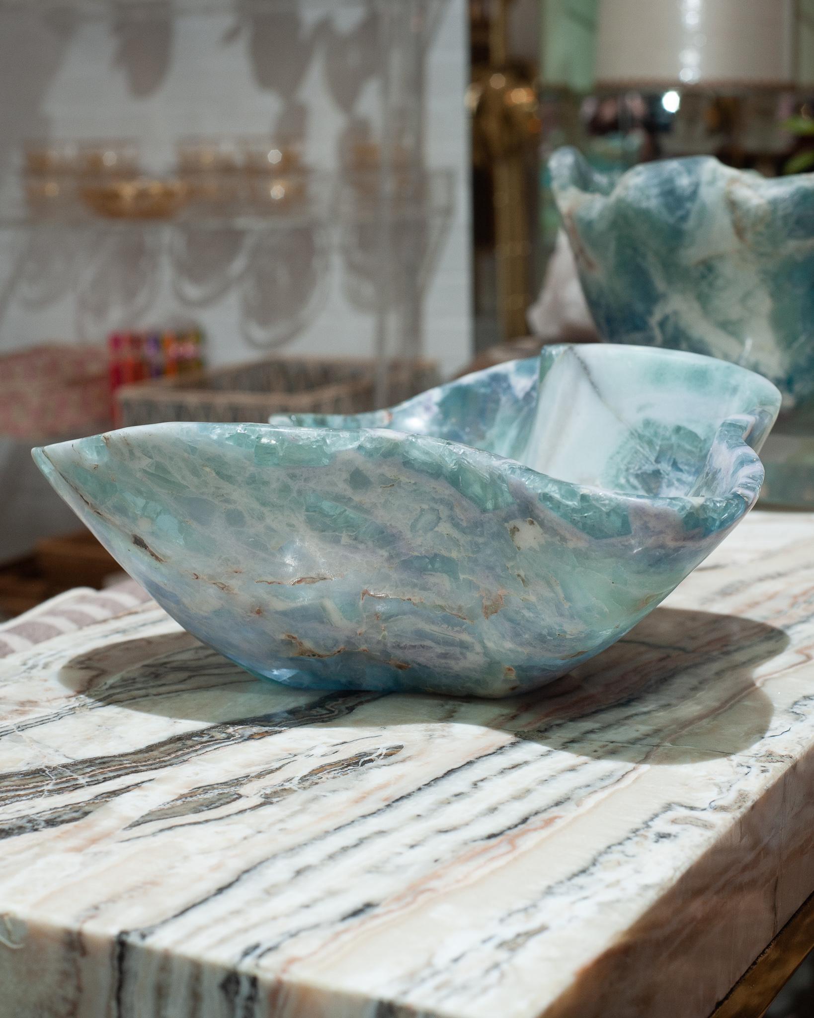 Invite the healing energy of fluorite into your home with an exceptional mineral bowl. This semi-precious stone is banded with green and blue and a natural raw edge.
