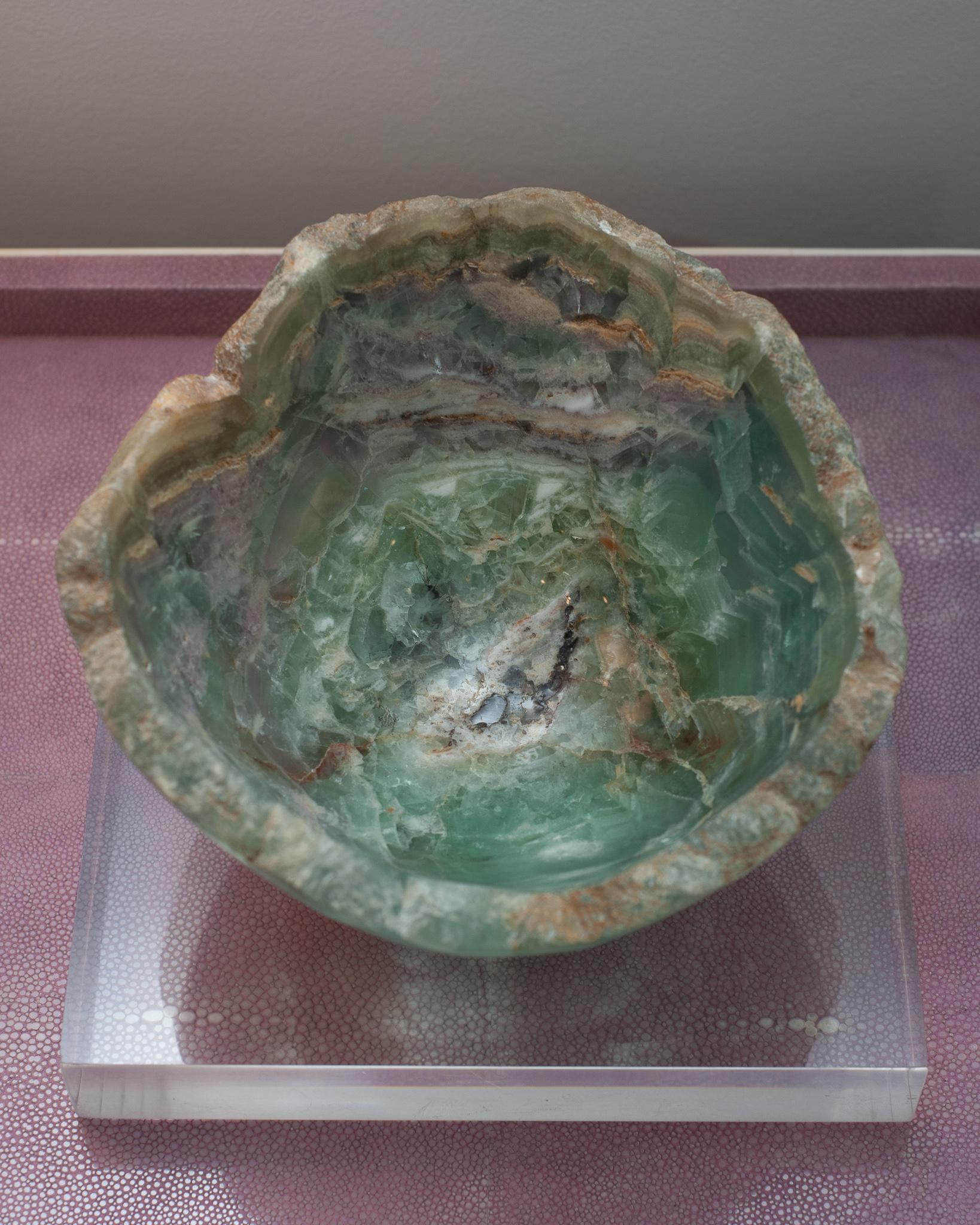 Invite the healing energy of fluorite into your home with an exceptional mineral bowl. This semi-precious stone is banded with green and purple and a natural raw edge.