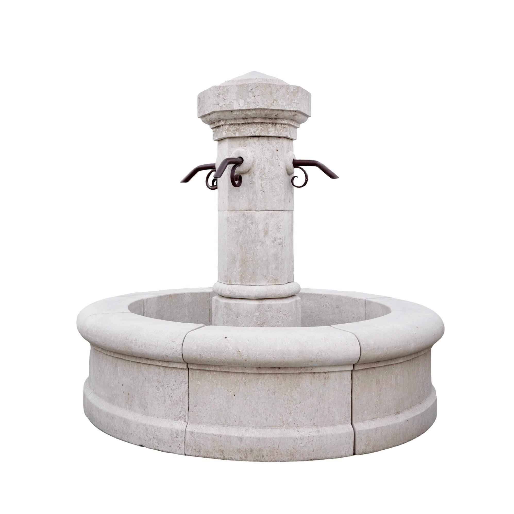 Una fontana centrale in pietra calcarea proveniente dalla Francia, meticolosamente scolpita a mano, con una vasca circolare progettata per raccogliere l'acqua in eccesso. Al centro della vasca si trova un pilastro centrale con quattro fori preforati