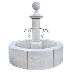Fontaine centrale contemporaine en pierre calcaire française