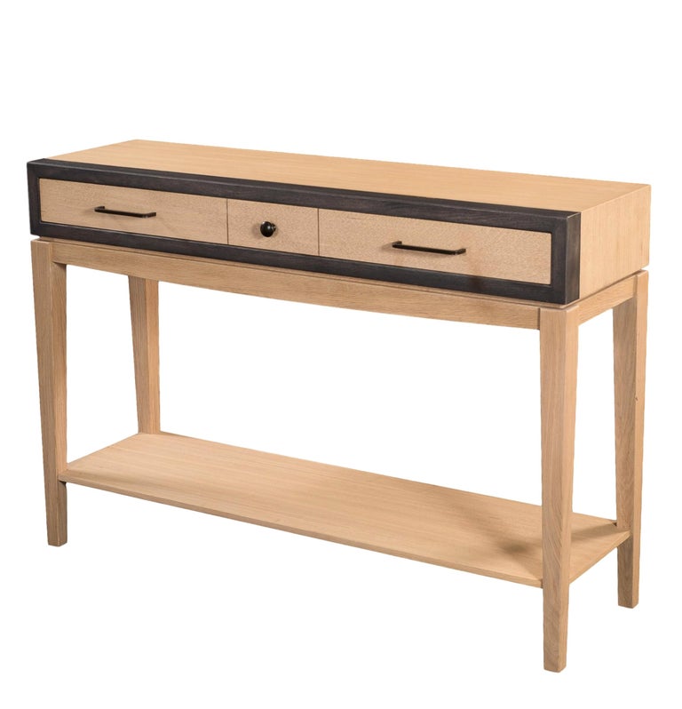 This Modern Console was designed by Christophe Lecomte. It is made of Solid French Oak. The sourcing of the solid wood comes from sustainably managed French forests.

This console is oak stained with the rim lacquered in black. 

It features 1