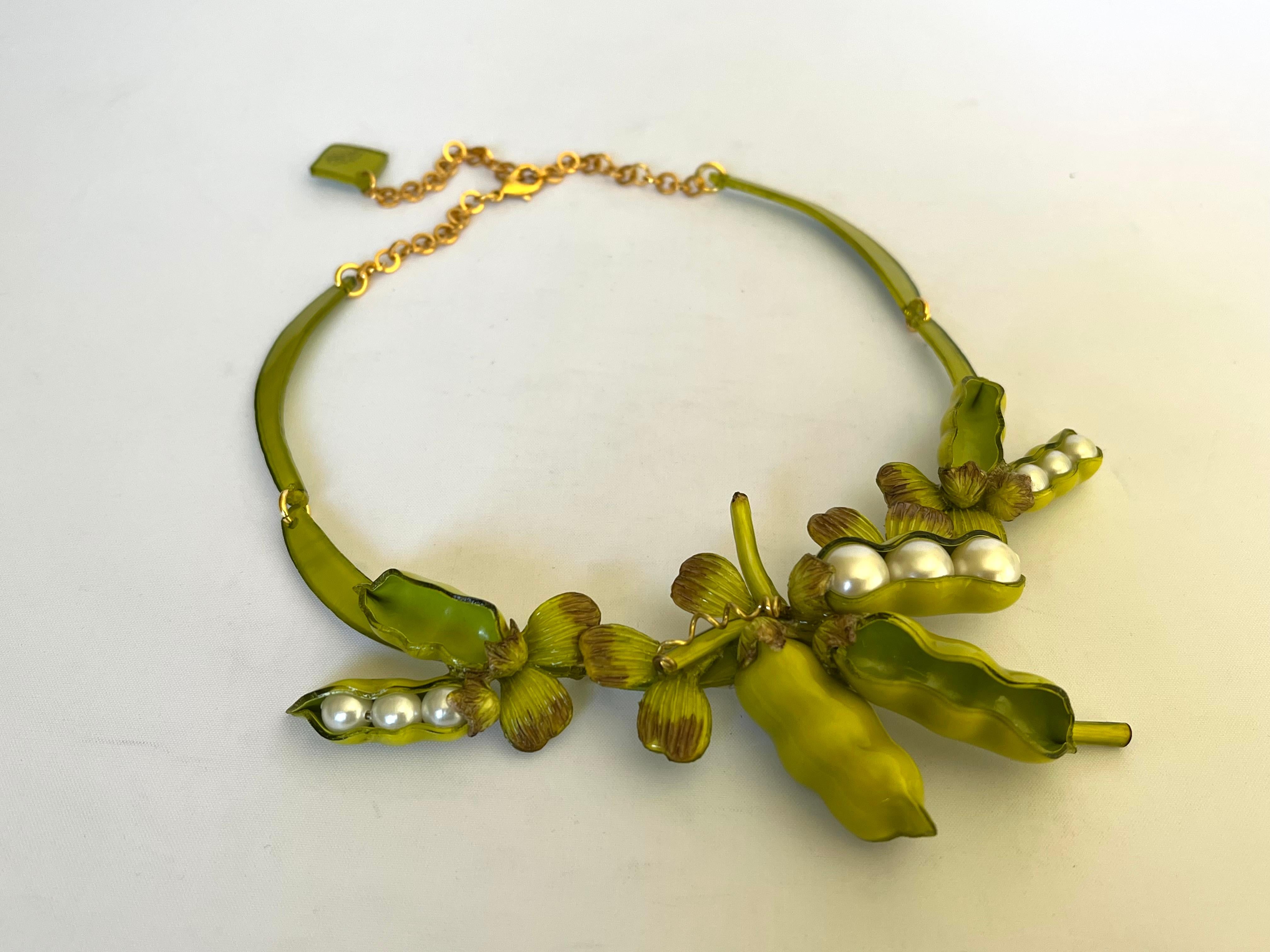 Contemporary designer giant peapod statement necklace - the bold necklace is comprised of a row of highly adorned enameline (resin and enamel) peapods. The oversized peapods feature hand-manipulated and etched acrylic details and large white faux