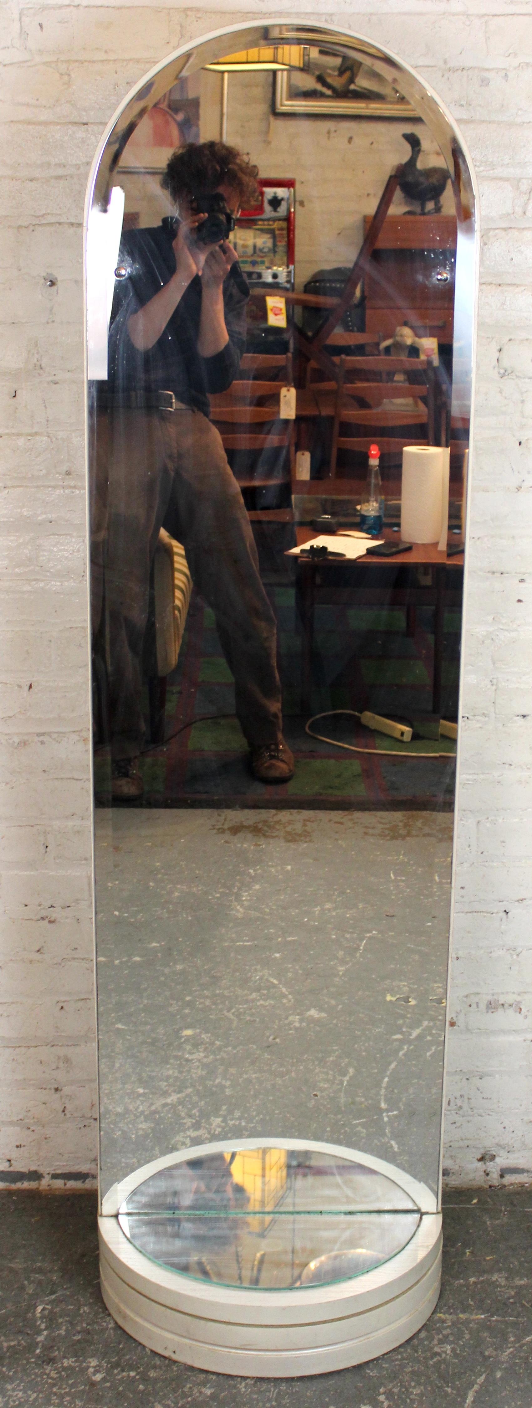 Specchio girevole in piedi contemporaneo realizzato in elegante legno bianco. Presenta uno specchio a figura intera che ruota per una visione regolabile e tre appendiabiti sul retro per riporli comodamente. Un design moderno e salvaspazio che