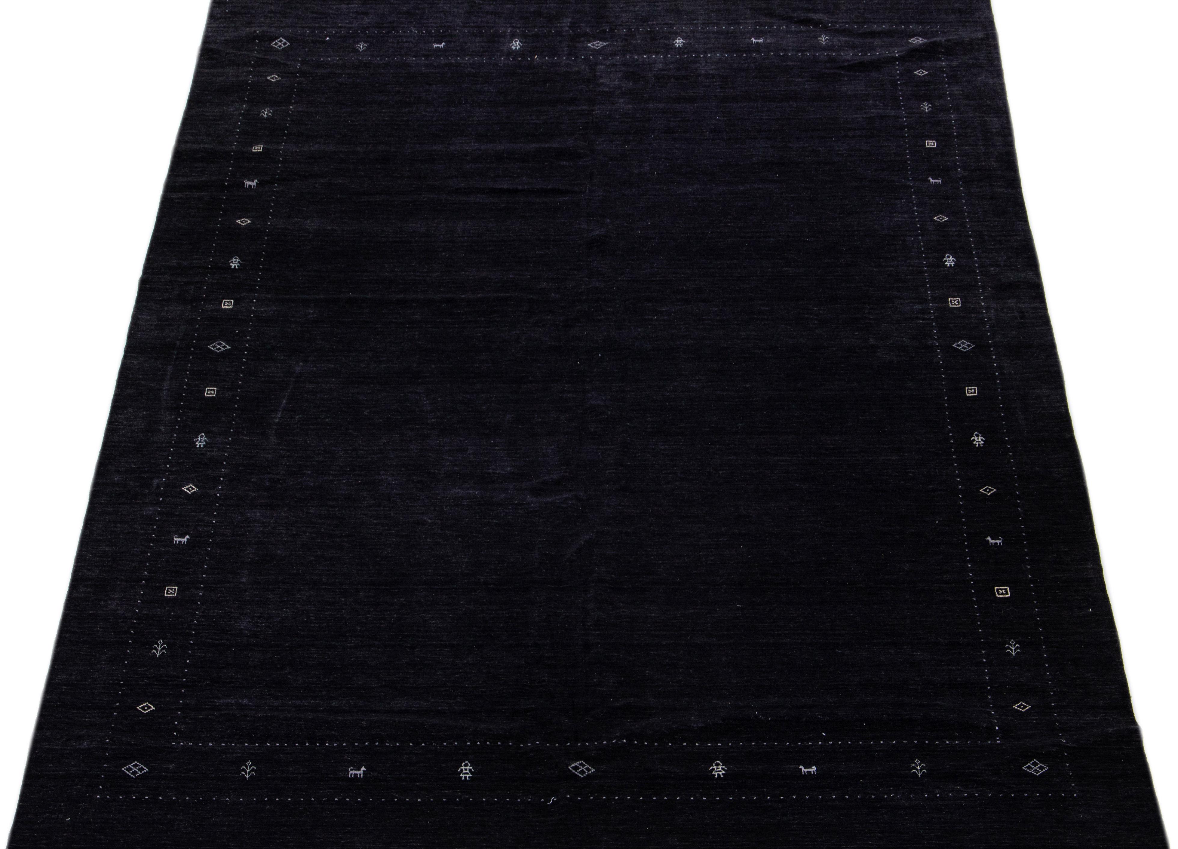 Boasting a modern Gabbeh-style pattern, this handwoven wool rug exhibits a black color field complemented by stylish white accents.

This rug measures: 12' x 15'.

Our rugs are professional cleaning before shipping.