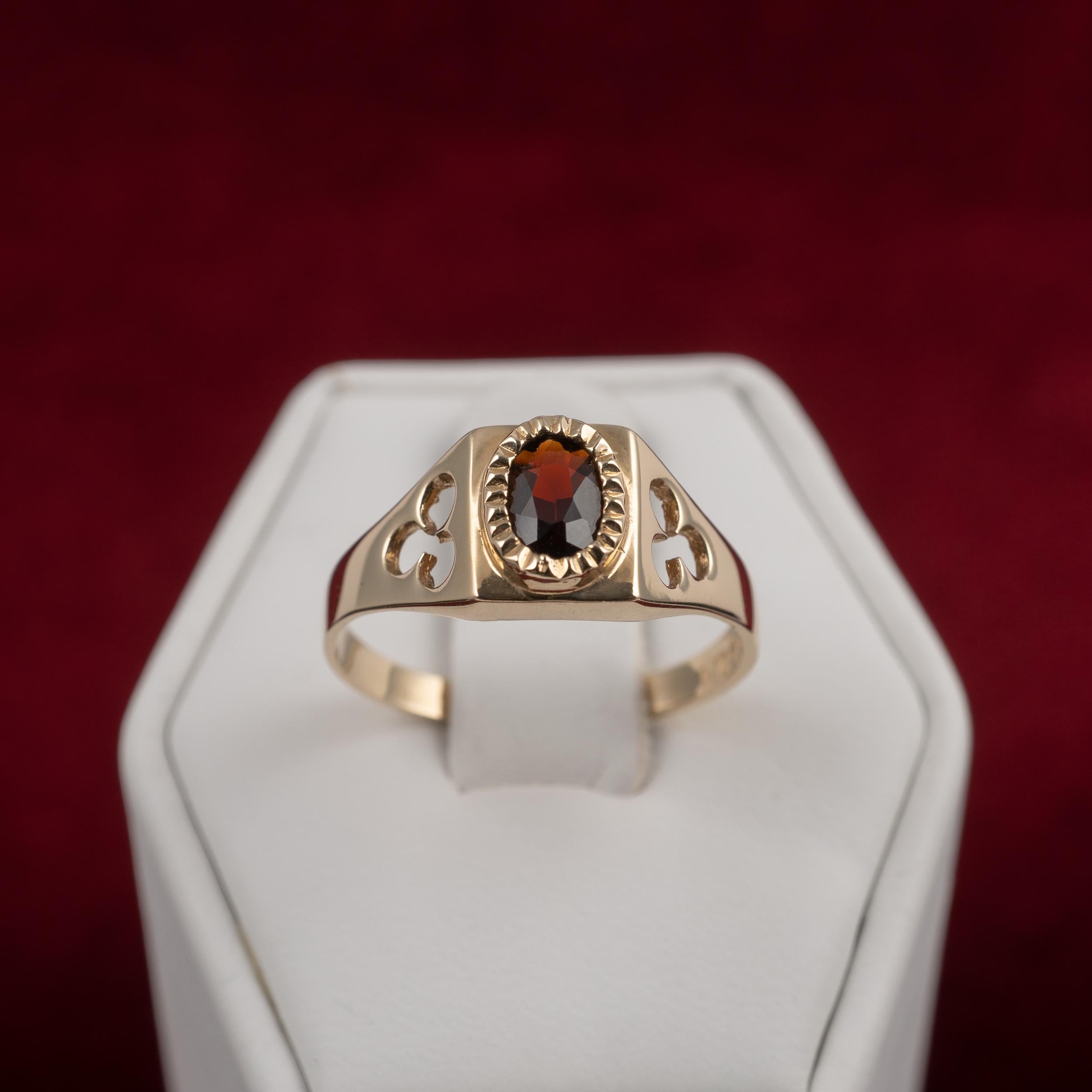 This contemporary garnet solitaire ring features oval-cut garnet and shamrock cut out shoulder design. Crafted in 9 karat gold, the ring is presented in very clean condition inside a neat leatherette ring box.

- Ring size: UK/AU size N/O  US ring