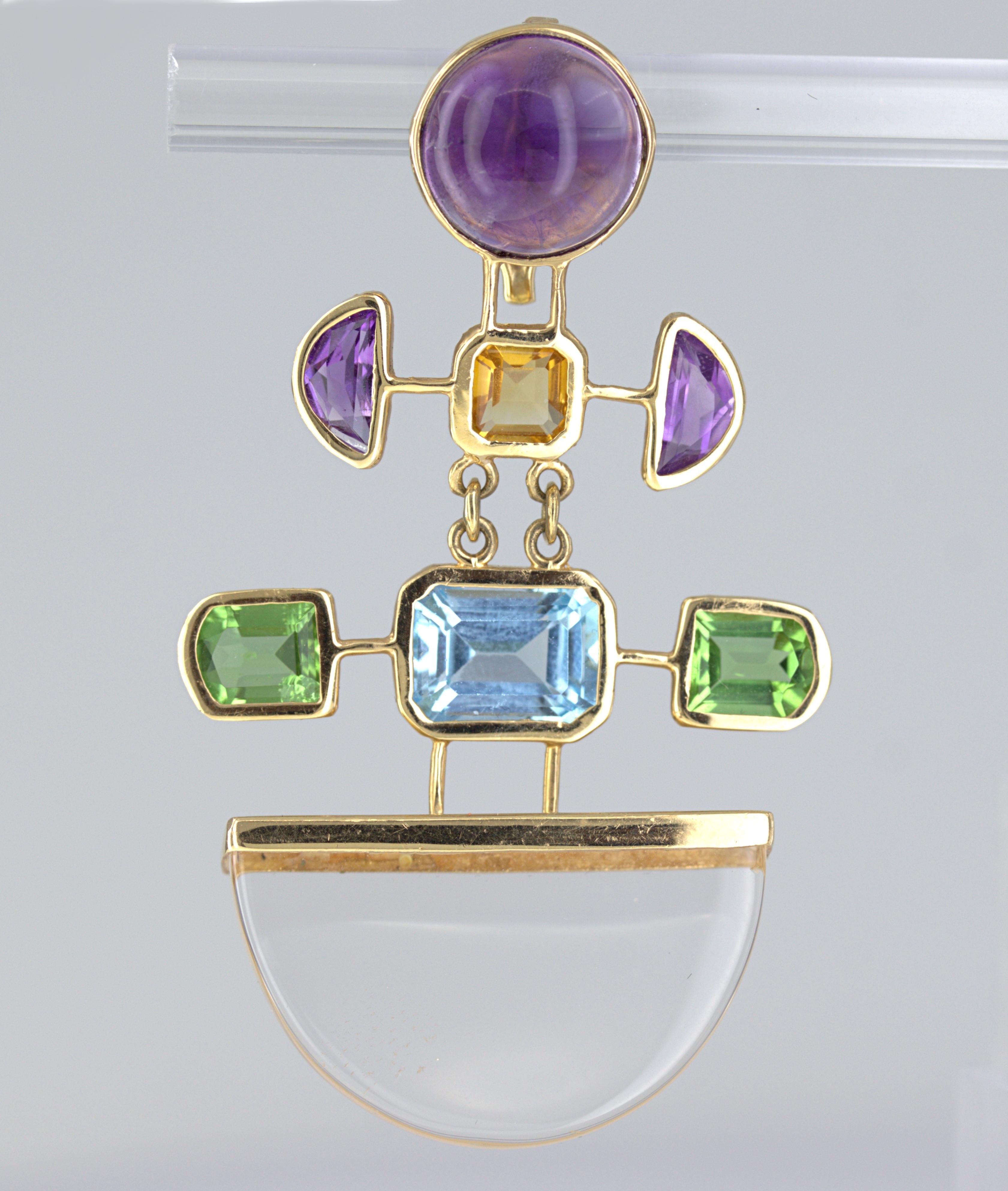 Featuring (1) carved rock crystal quartz wedge, (1) round amethyst cabochon, (1) emerald-cut blue topaz, (1) emerald-cut citrine, (2) amethyst half-moons, and (2) window-shaped peridots, all bezel set in an articulated, 14k yellow gold