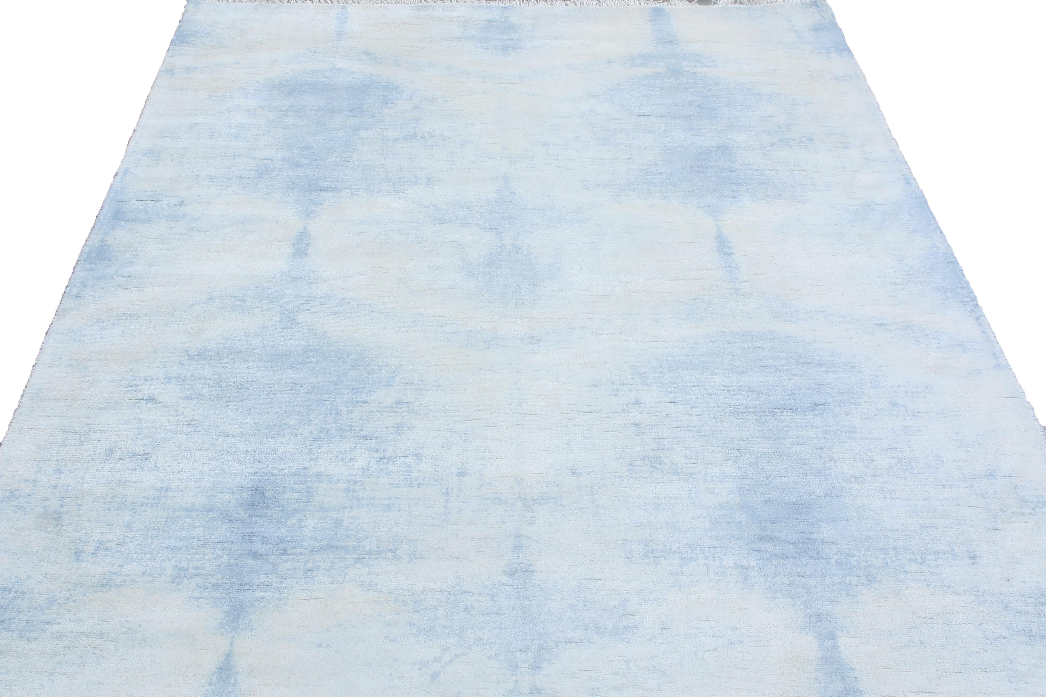 Hand knotted in 65 percent wool and 25 percent silk originating from India, this geometric runner enjoys a luminous, borderless geometric azure blue field design against a complementary ivory background, lending versatility and natural light under