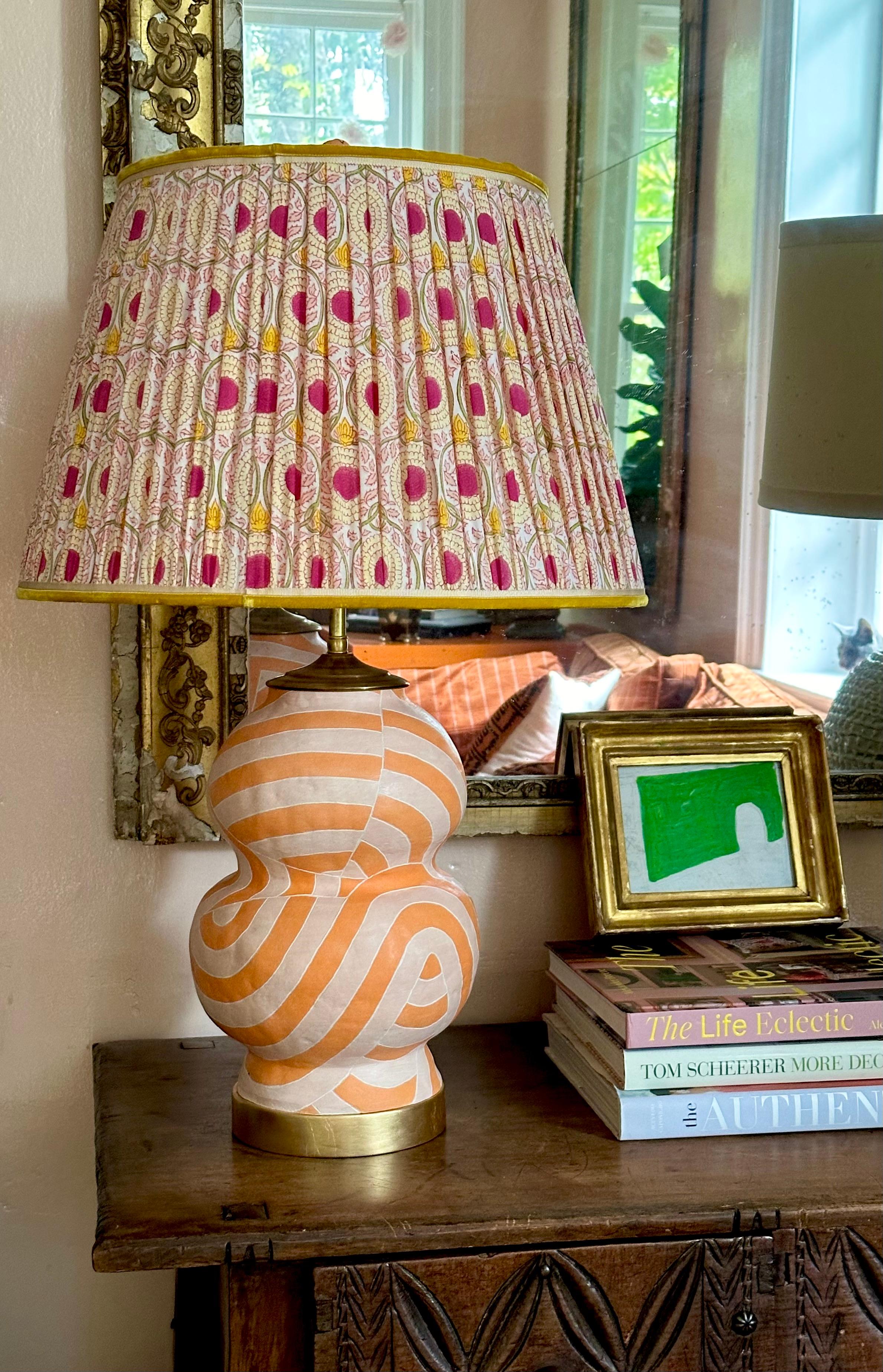 Hand painted double gourd geometric patterned lamp in orange and peach with incised edges, gold leaf base, waxed matte finish, live brass hardware, double sockets, adjustable finial with a max height of 26.5