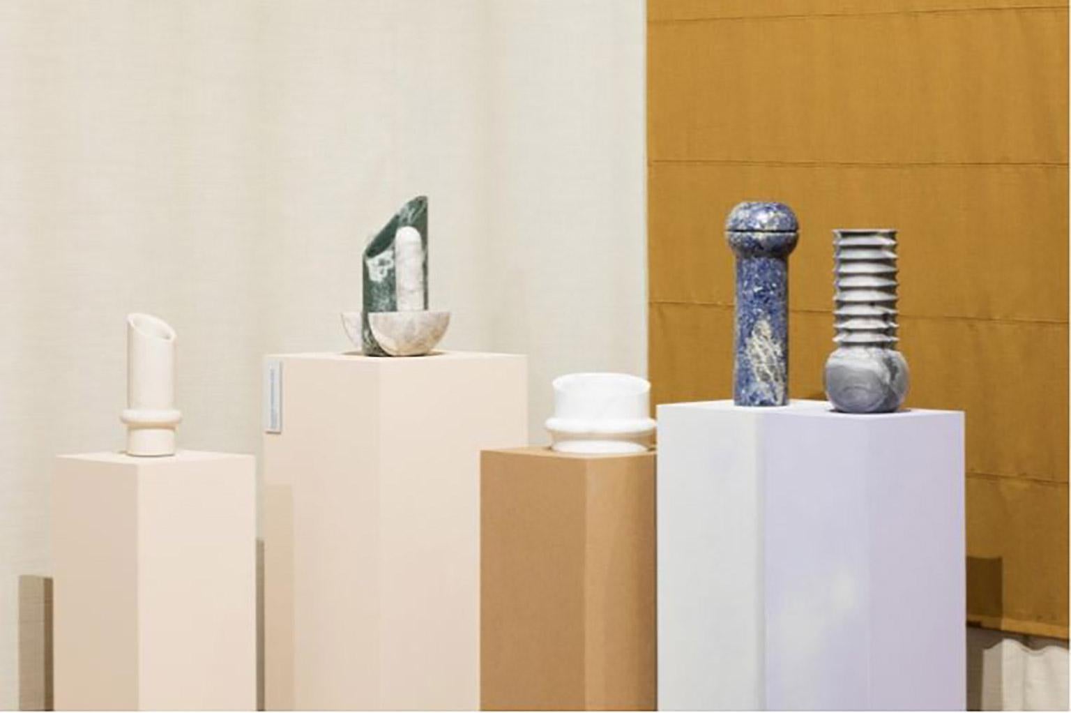 Vase géométrique sculptural en marbre Botticino, collection Simultanea. Les forces centripètes, centrifuges et de mouvement sont canalisées dans des formes en pierre. Une rotation sur l'axe devient un vase, tandis qu'une coupe inclinée suggère un