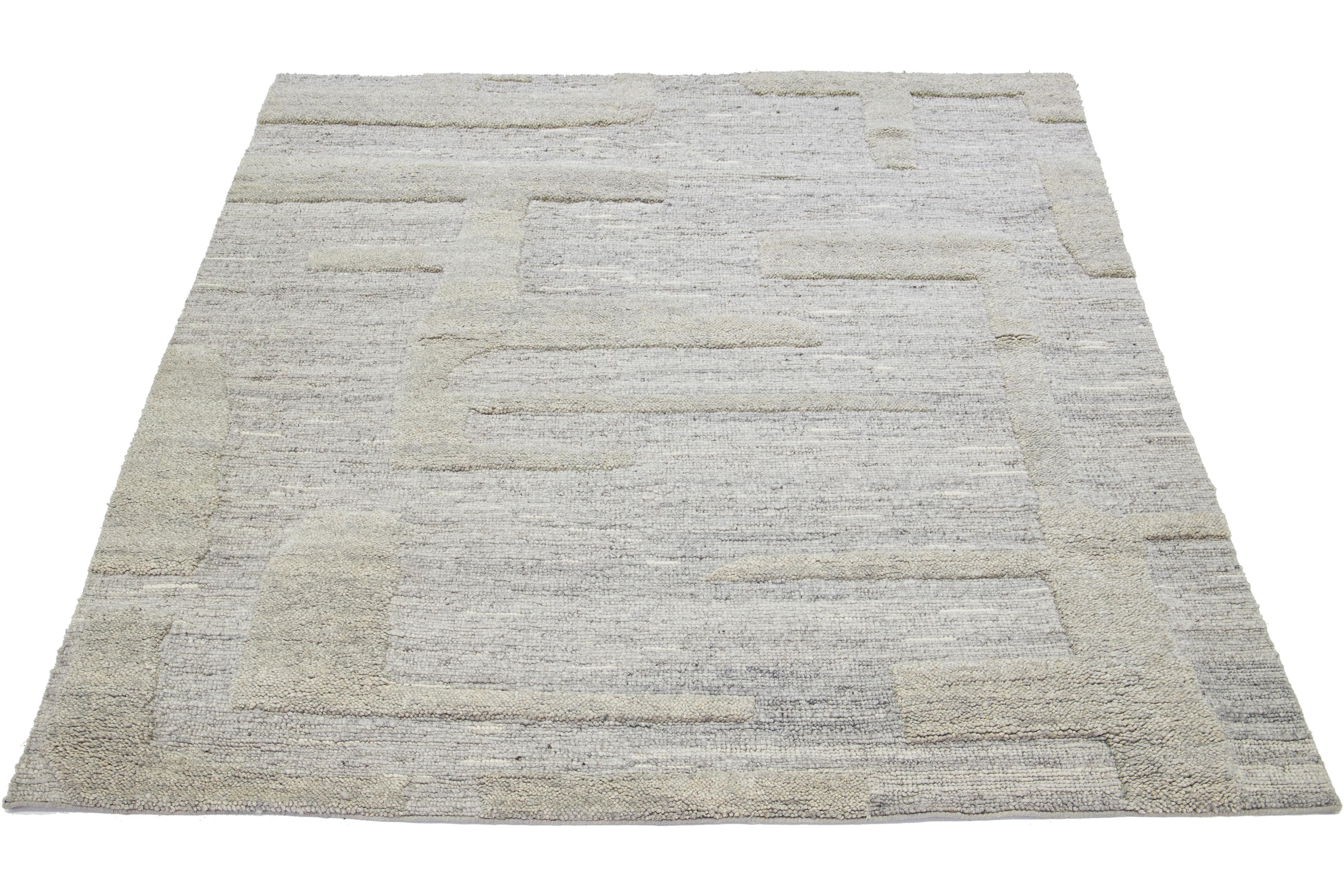 Ce tapis en laine de style marocain noué à la main présente un magnifique design moderne sur fond gris naturel. Il présente un superbe motif géométrique.

Ce tapis mesure 8' x 10'.
