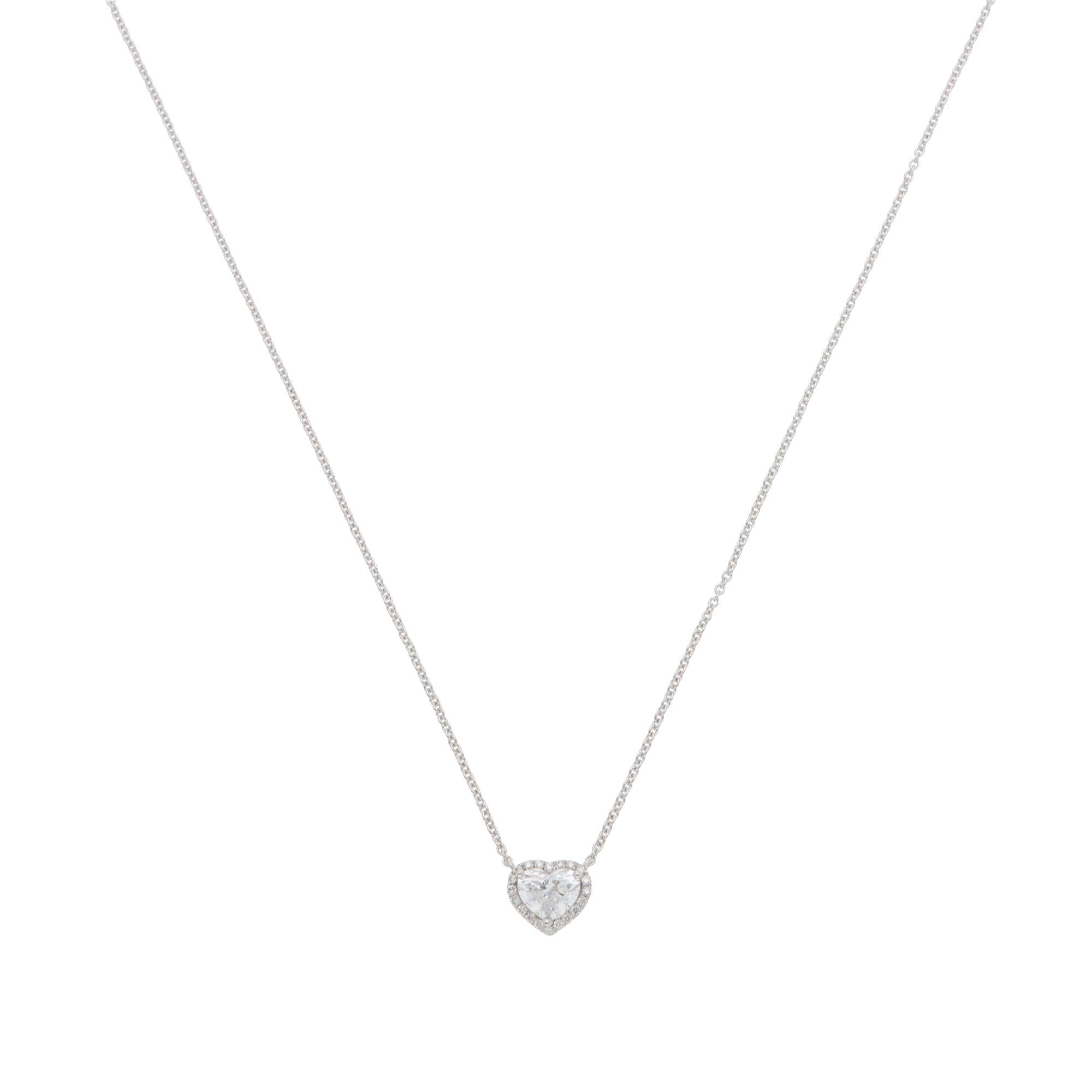 A beautiful contemporary heart-shaped diamond cluster pendant necklace set in 18k white gold.

The necklace centrally features a spectacular heart-shaped diamond, which is set with 20 round brilliant-cut diamonds arount. The pendant connects to an