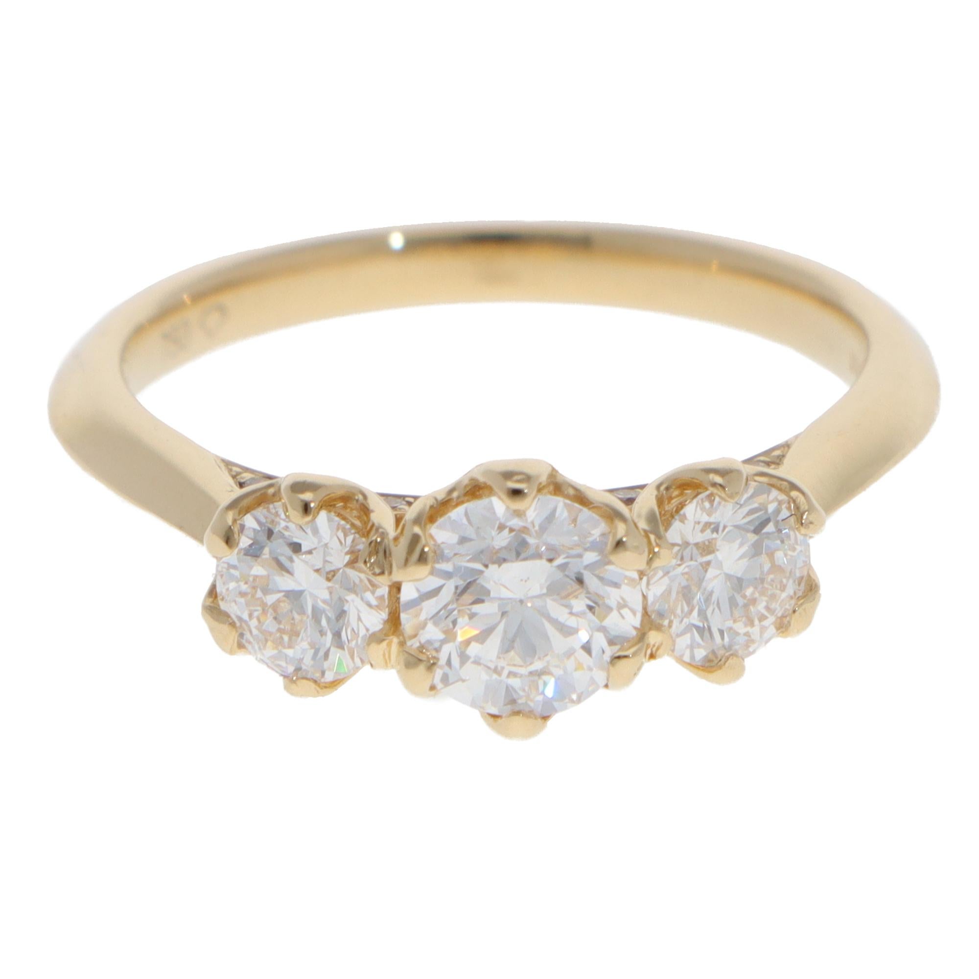 Un bellissimo anello contemporaneo con tre pietre di diamante incastonate in oro giallo 18 carati.

L'anello è composto da un diamante rotondo centrale con taglio a brillante e da due diamanti più piccoli sui lati. Le pietre sono incastonate a sei