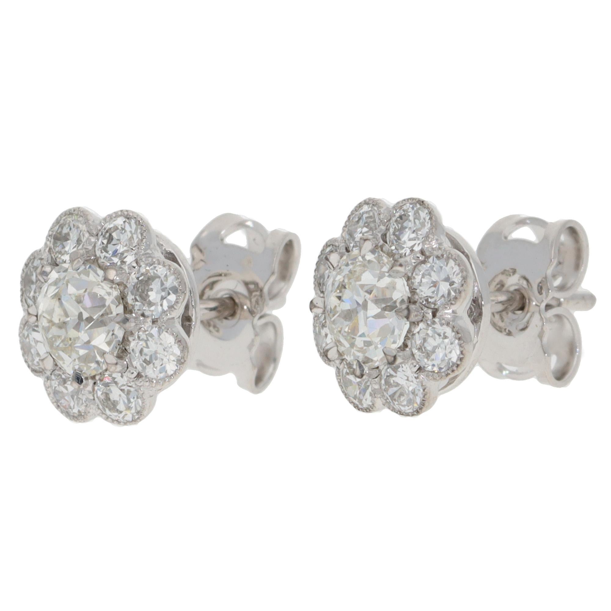 An elegant pair of contemporary diamond cluster stud earrings set in 18k white gold.

Each earring depicts a floral cluster motif centrally set with 9 old European cut diamonds. The earrings are secured to reverse with a post and butterfly