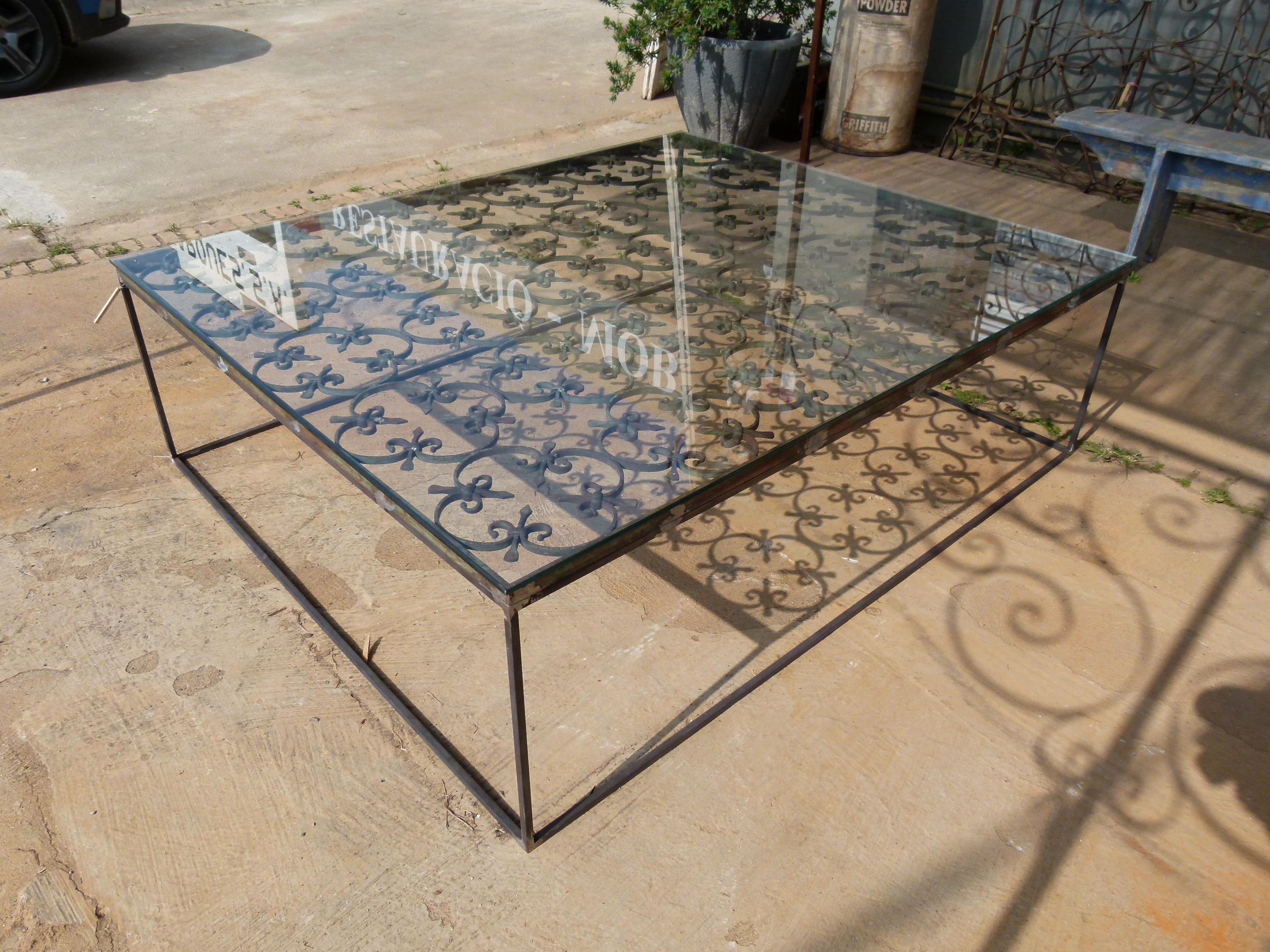  A nice combination of modern and old. This simple and elegant design is the result of  recycling and new.  The base  is made with recycled 19th century iron fence and the top with a nice rectangular shaped glass that allows to see the nice worked