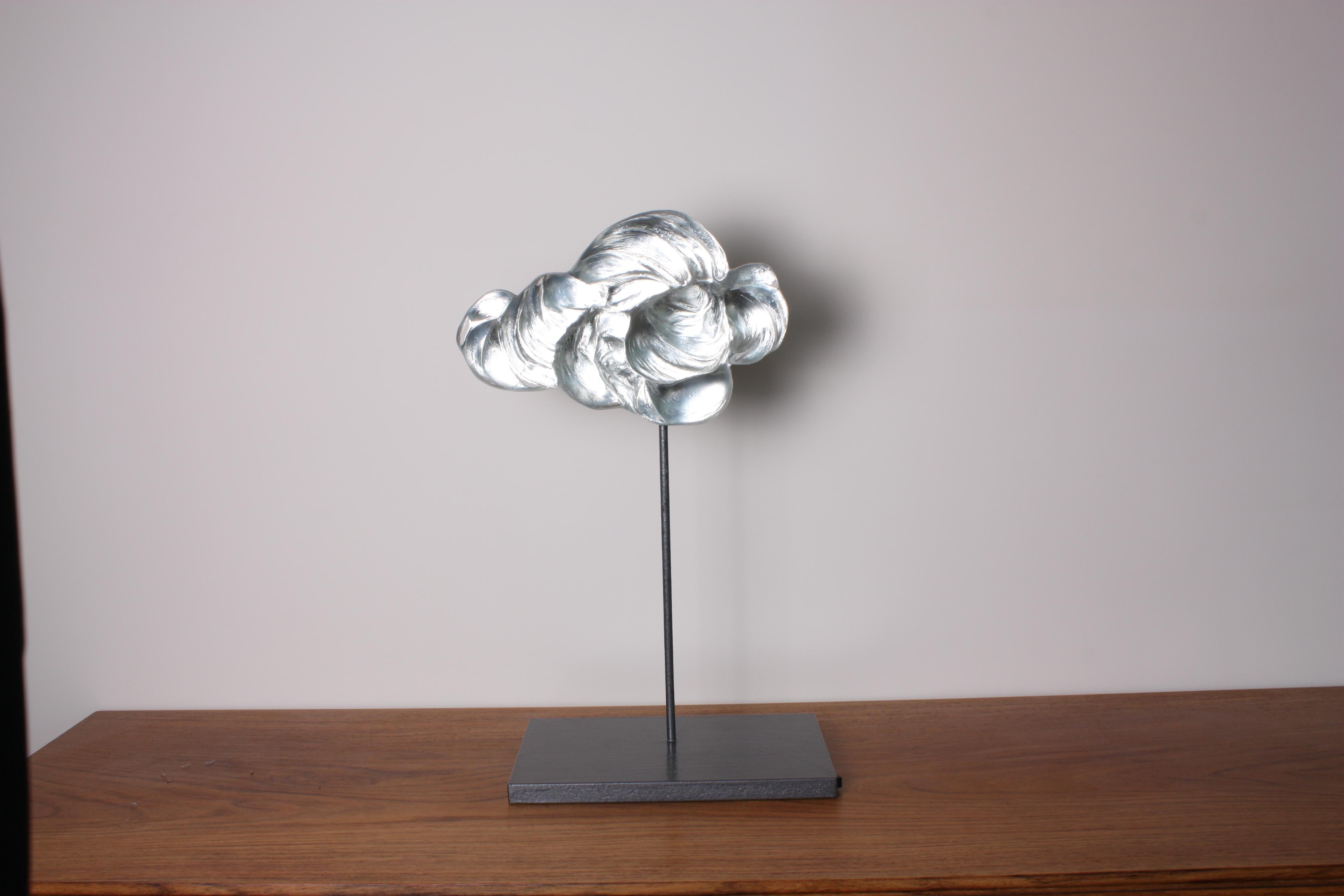 Contemporary glass sculpture representing a billowing cloud made using the pâte de verre technique, on a metal and wood pedestal. The artist casts melted glass in carefully hand-sculpted molds. Different thicknesses of glass create depth and