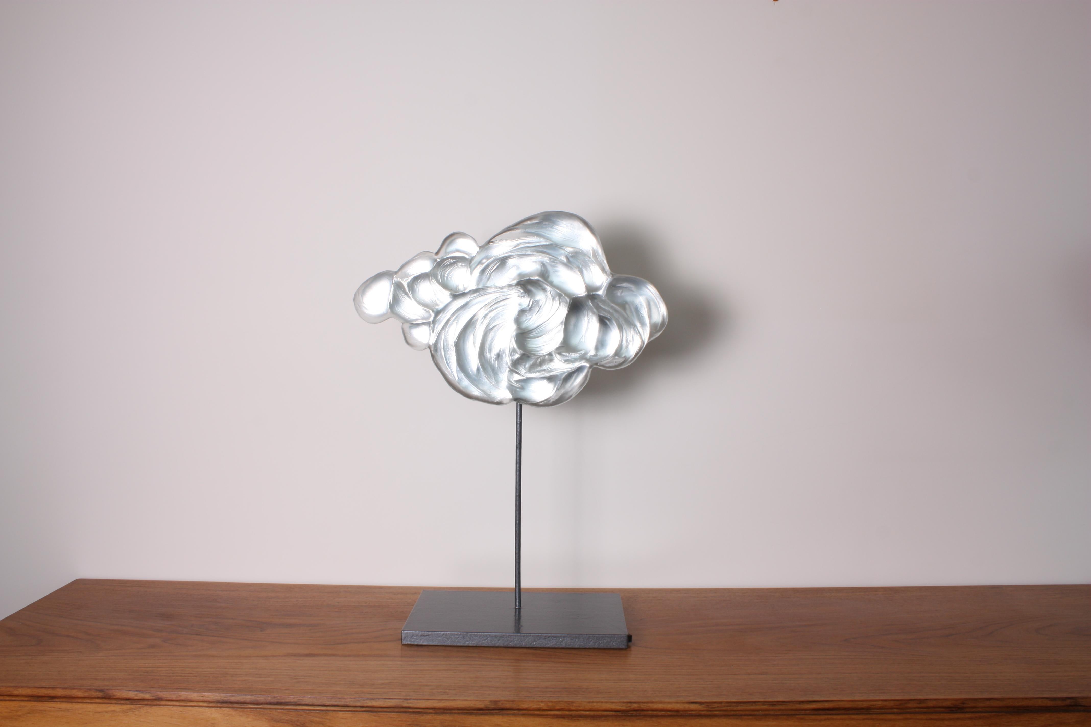 Contemporary glass sculpture representing a billowing cloud made using the pâte de verre technique, on a metal and wood pedestal. The artist casts melted glass in carefully hand-sculpted molds. Different thicknesses of glass create depth and