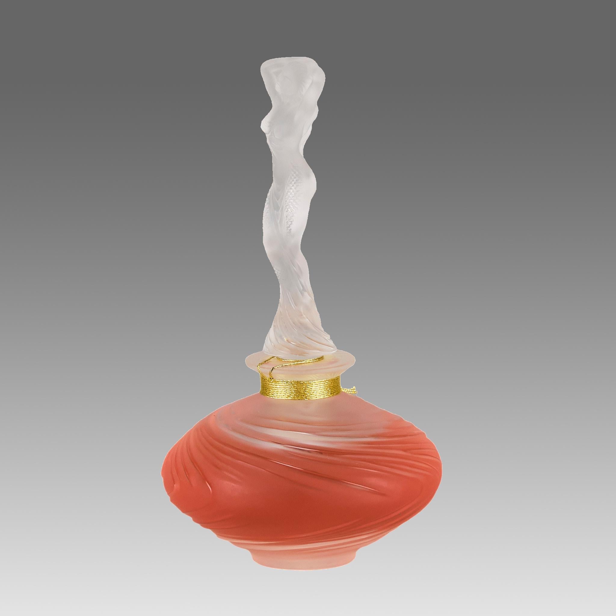 A stunning French Limited edition Crystal glass Flacon with a shaped stopper in the form of a sensual beauty wearing a loosley draped dress with her arms above her head, exhibiting fine detail, signed Lalique France and numbered to base.

ADDITIONAL