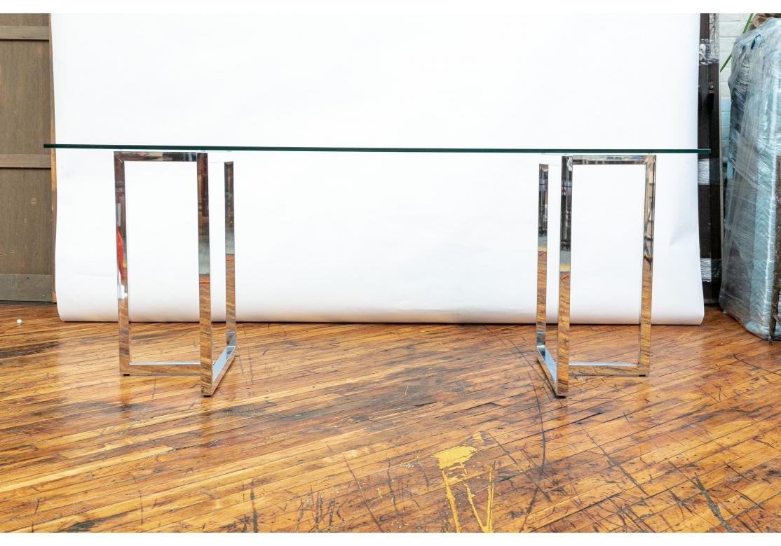 Los soportes cromados tienen forma cuadrada, con la parte superior y la base en forma de T.  Con una larga tapa de cristal transparente. Útil como mesa de comedor o de escritura. 

Dimensiones: L. 72