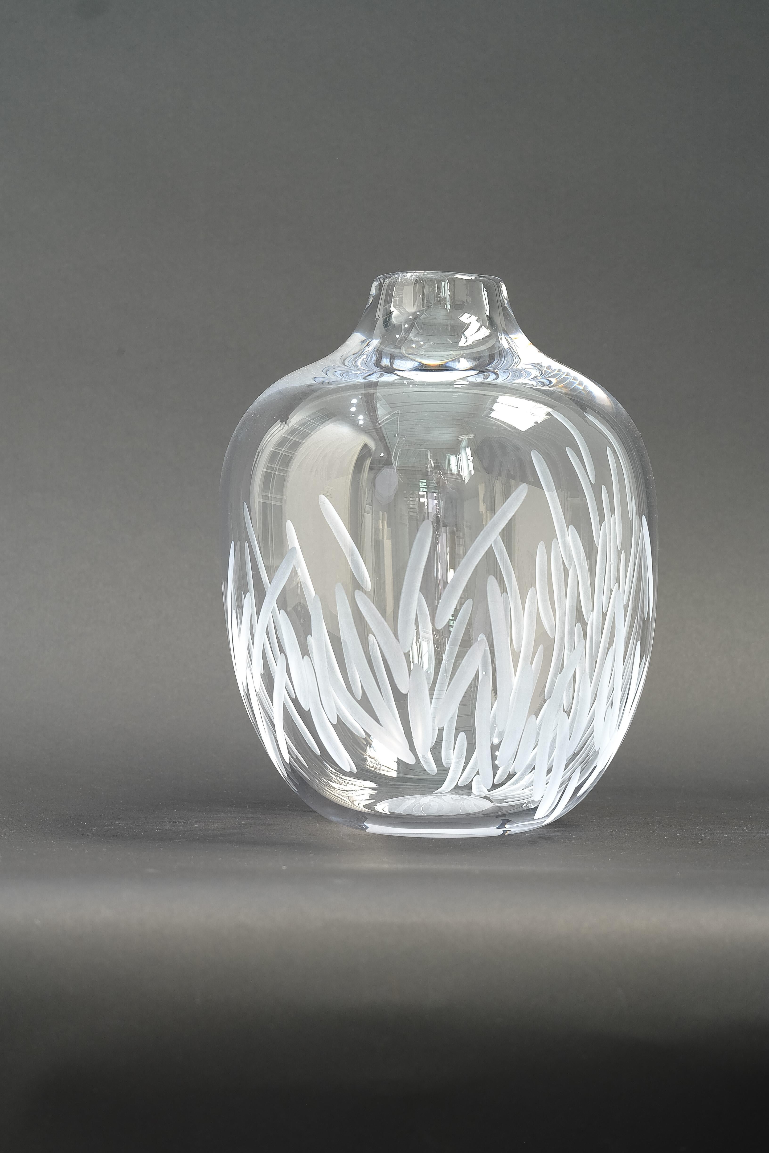 A clear glass vase blown and engraved by design duo Vezzini & Chen.

Vezzini & Chen’s work is defined by the artful marriage of hand carved ceramics and blown glass. The collections tread a fine line between functional and conceptual, with the