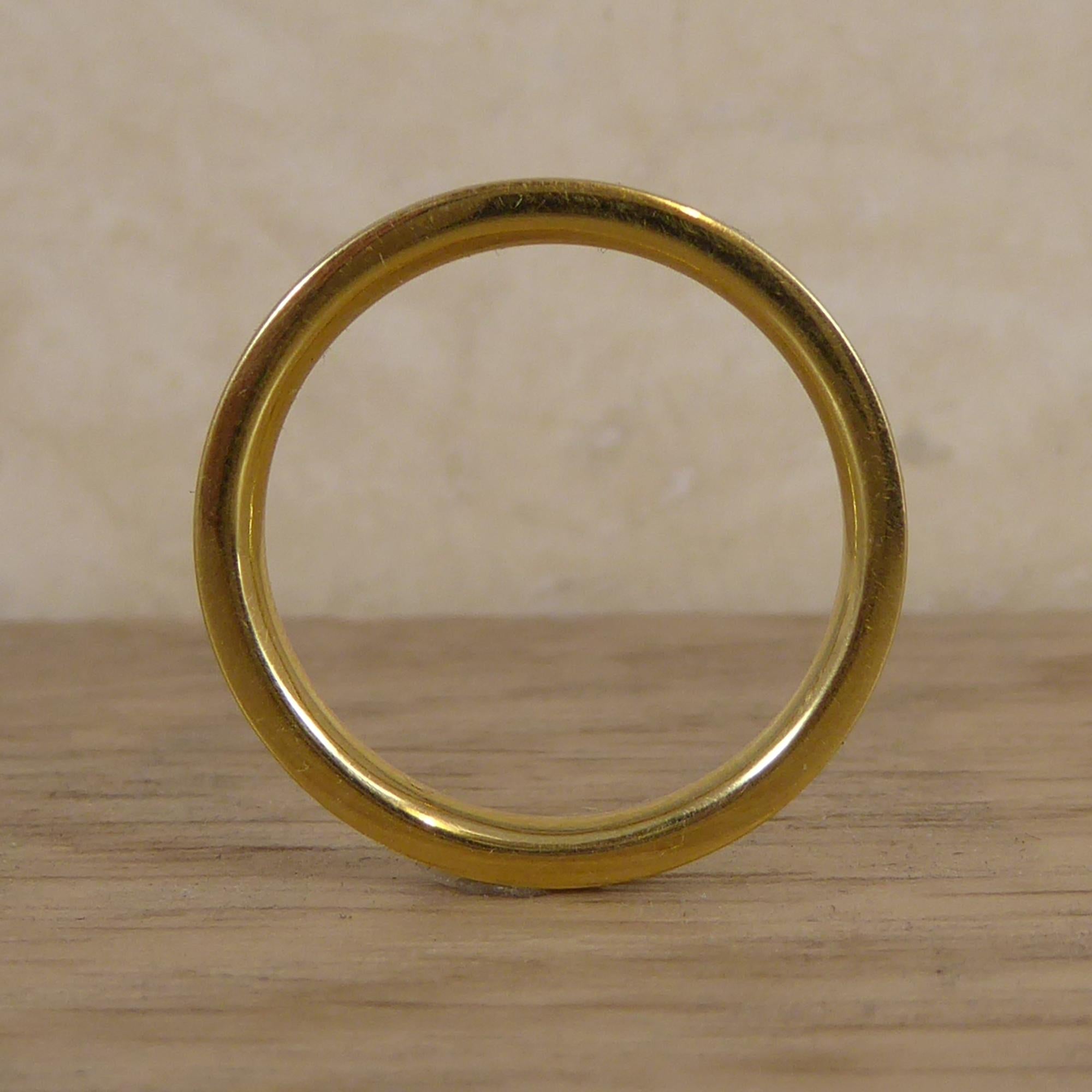 A strikingly modern band suitable for wearing as either a contemporary wedding ring or designer dress ring.  Crafted from a unison of yellow metal testing as 18ct yellow gold with an inner circle of titanium.  This fashion ring is finger size 5.5