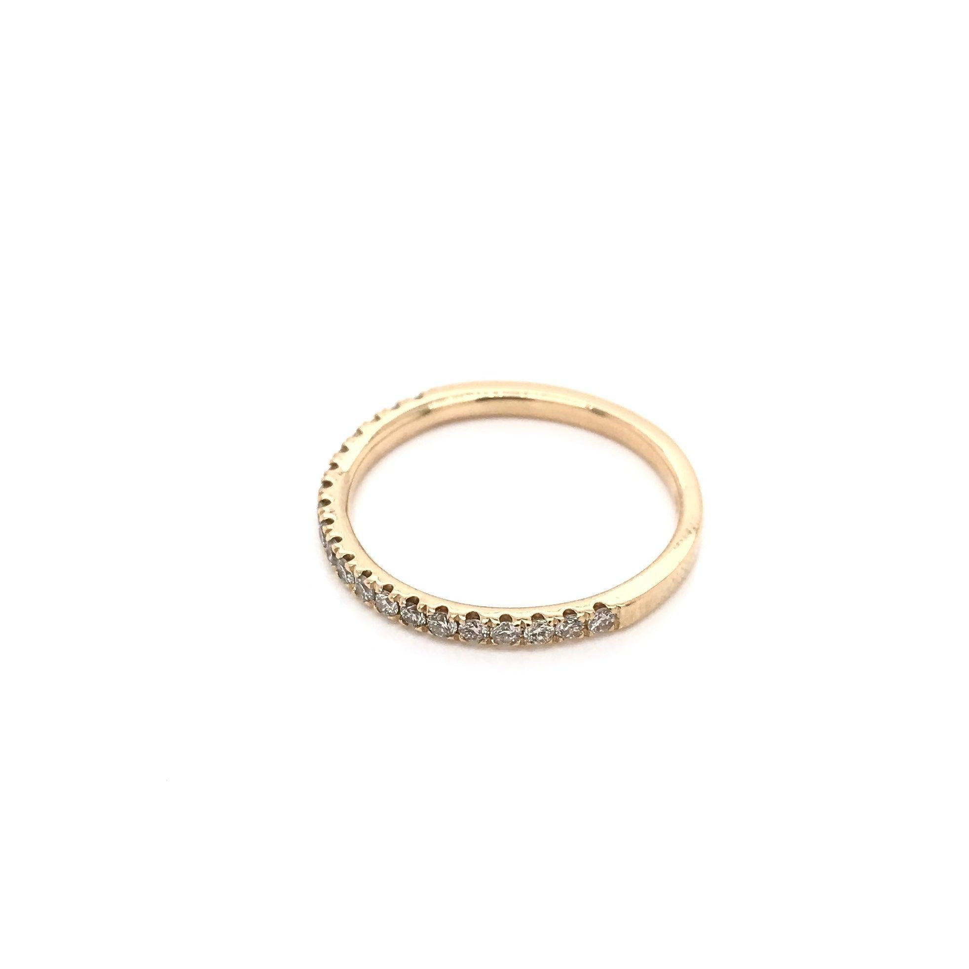 This 14k gold wedding band is a contemporary piece. The band features 20 sparkling white diamonds set along the top half of the shank and has a total combined diamond weight of approximately 0.28 carats. An instant classic, this gorgeous diamond
