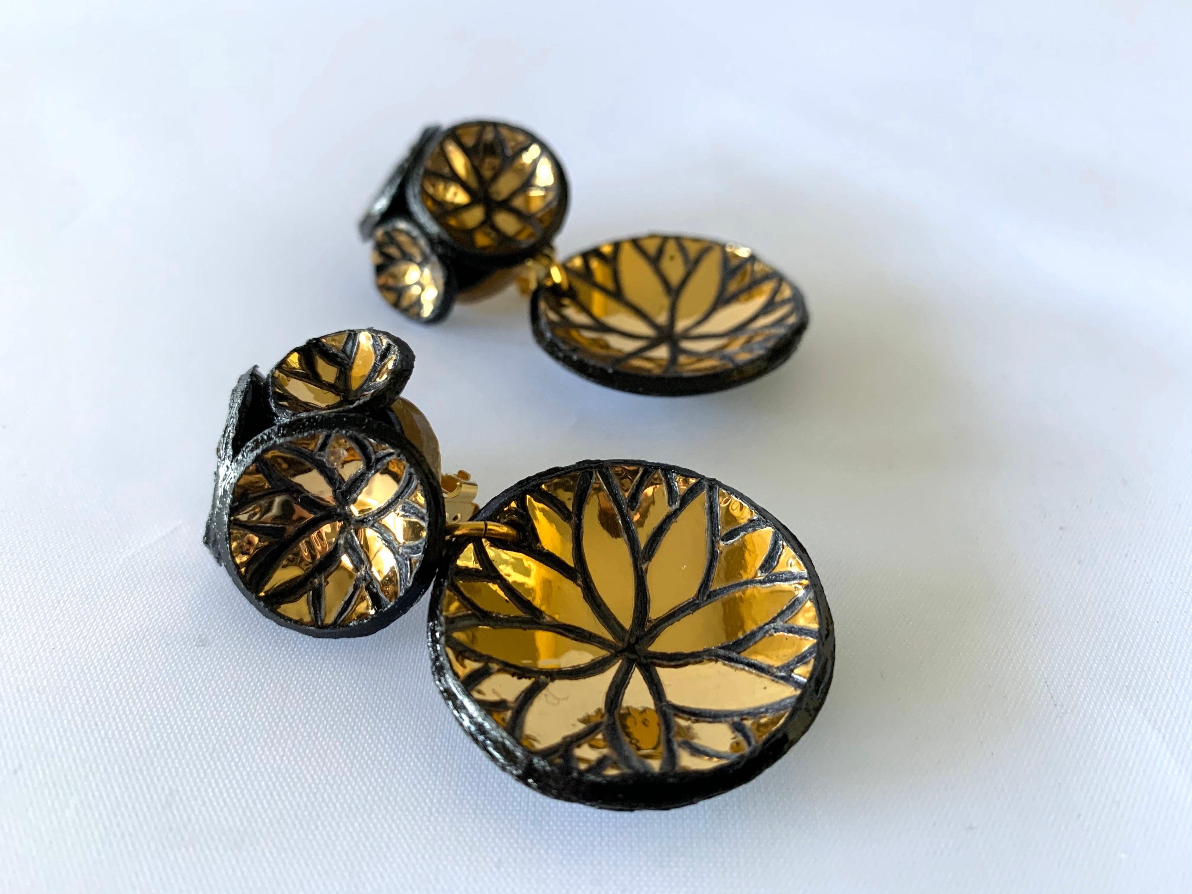 Light and easy to wear, these handmade artisanal contemporary disk earrings were made in Paris by Cilea. Concave black resin discs embellished with metallic gold leaf, clustered together to form a powerful statement piece - signed Cilea Paris on the