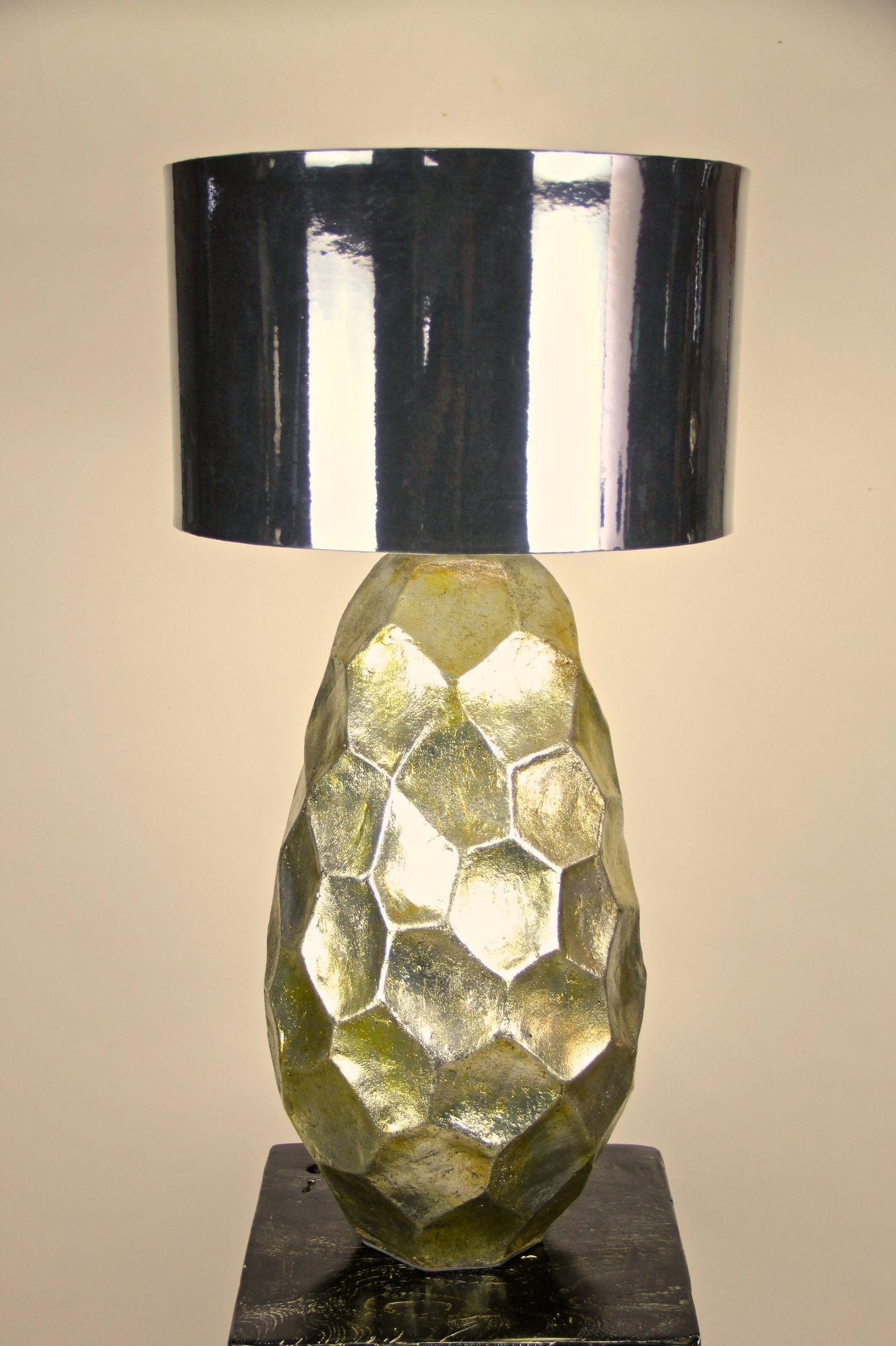 Preciosa lámpara de sobremesa contemporánea de cerámica dorada esmaltada sobre un pedestal de teca negra. El cuerpo de cerámica bulbosa de gran diseño recuerda a los panales de forma irregular y muestra una cálida superficie vidriada dorada, con