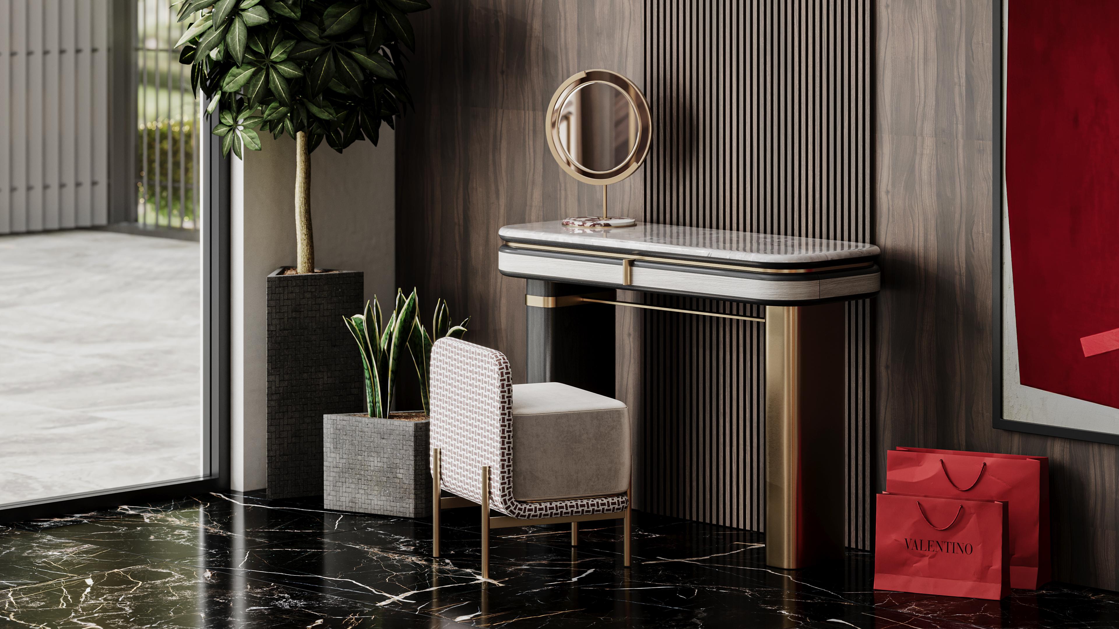 Gralto dressing table features a sleek, rounded design with two distinctive legs—one in brushed brass and the other in black wood. This combination of materials creates a balanced look of modern sophistication and warmth.