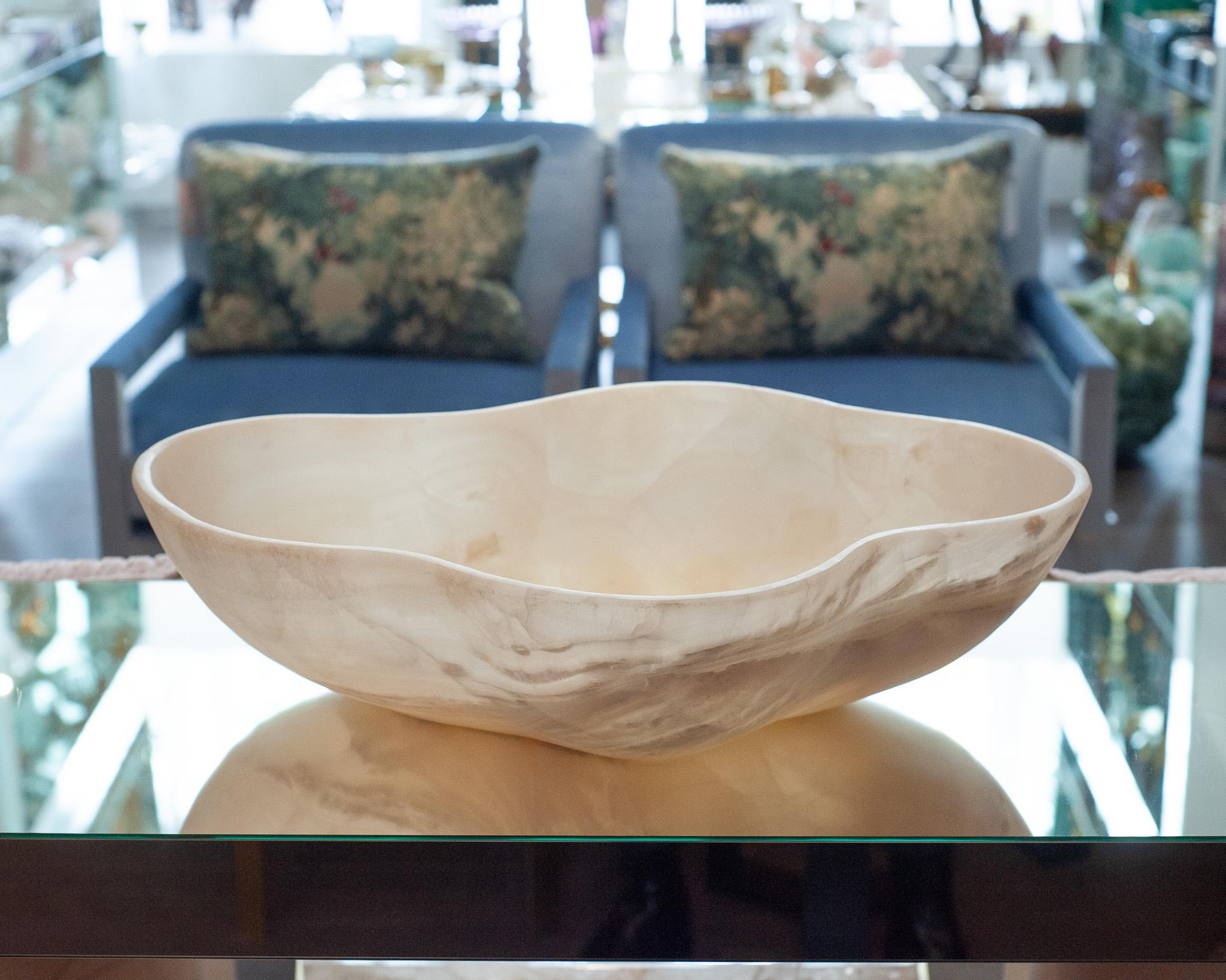 Invite the healing energy of onyx into your home with this remarkable, hand-carved mineral bowl. Crafted from a single piece of onyx, the bowl showcases swirls of white and off-white. Its honed finish gives the surface a soft, matte texture. This