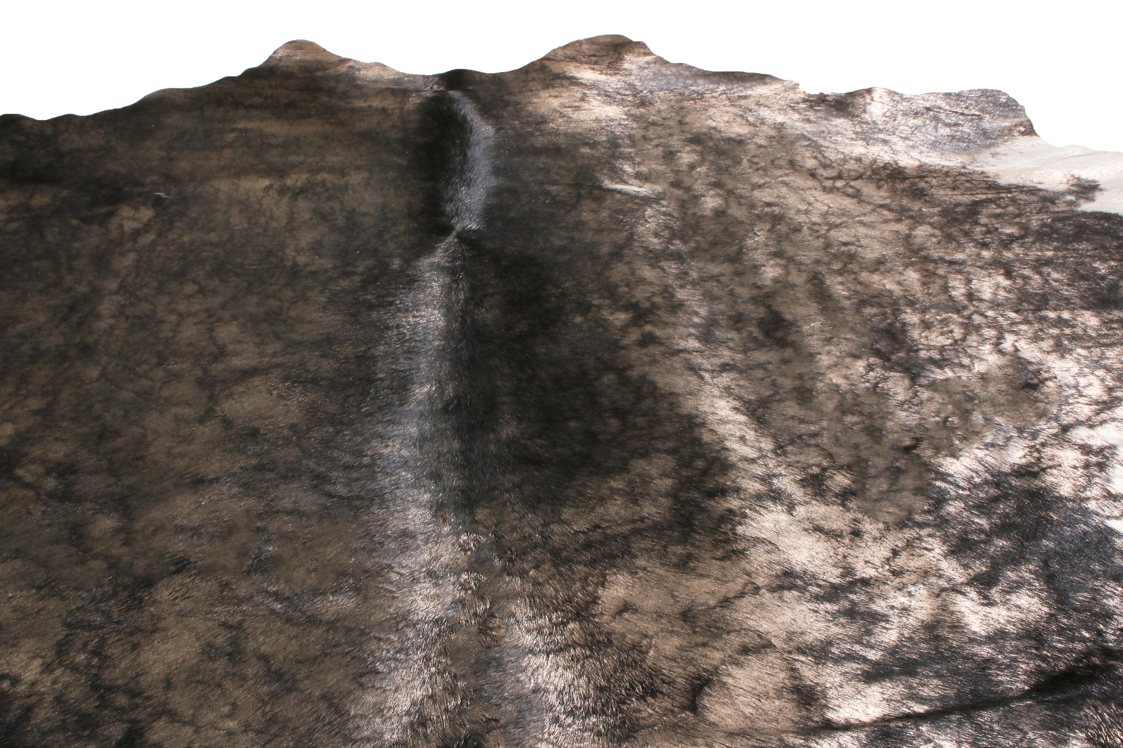 Originaire des États-Unis, ce tapis contemporain en cuir de vachette présente un abrash naturel de couleur grise et blanche avec des accents noirs sur sa peau de cuir, un choix distingué pour les espaces plus luxueux. Cette tannerie a conservé la