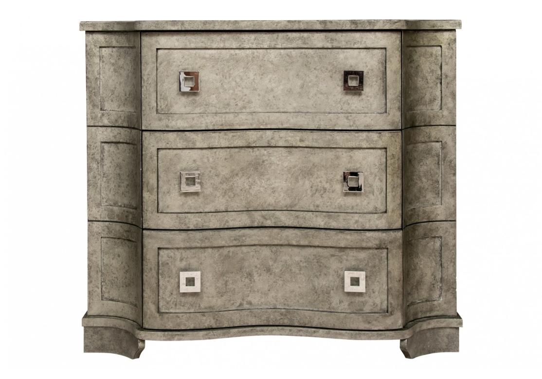 A shaped chest of three long drawers in a mottled gray finish reminiscent of Shagreen. With square nickel openwork pulls. Raised on shaped feet front and back. Unpainted back and inside the drawers. 

Dimensions: L. 41