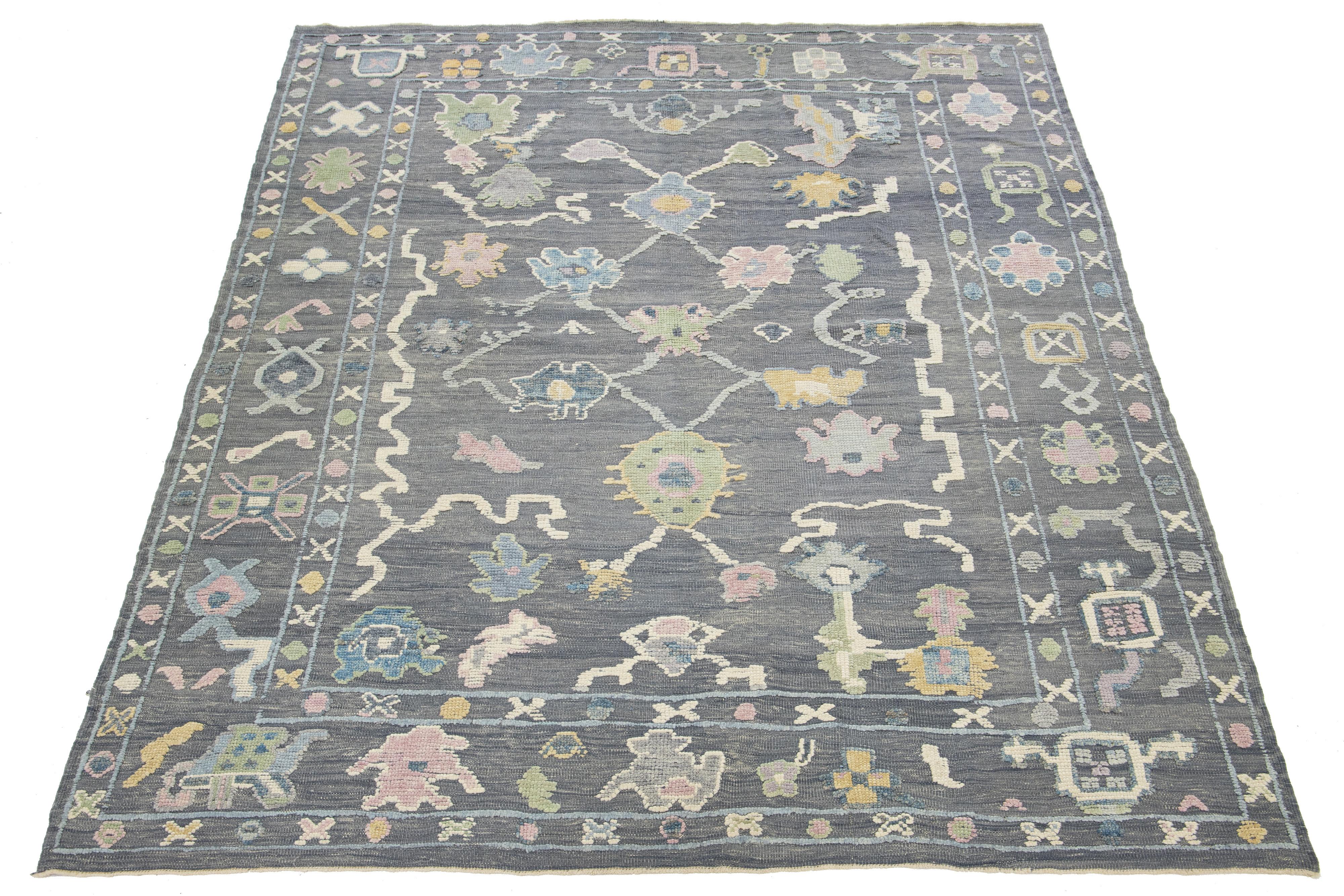 This exquisite hand-knotted wool rug boasts a stunning gray base embellished with a captivating multicolor floral pattern. 

This rug measures 9'3