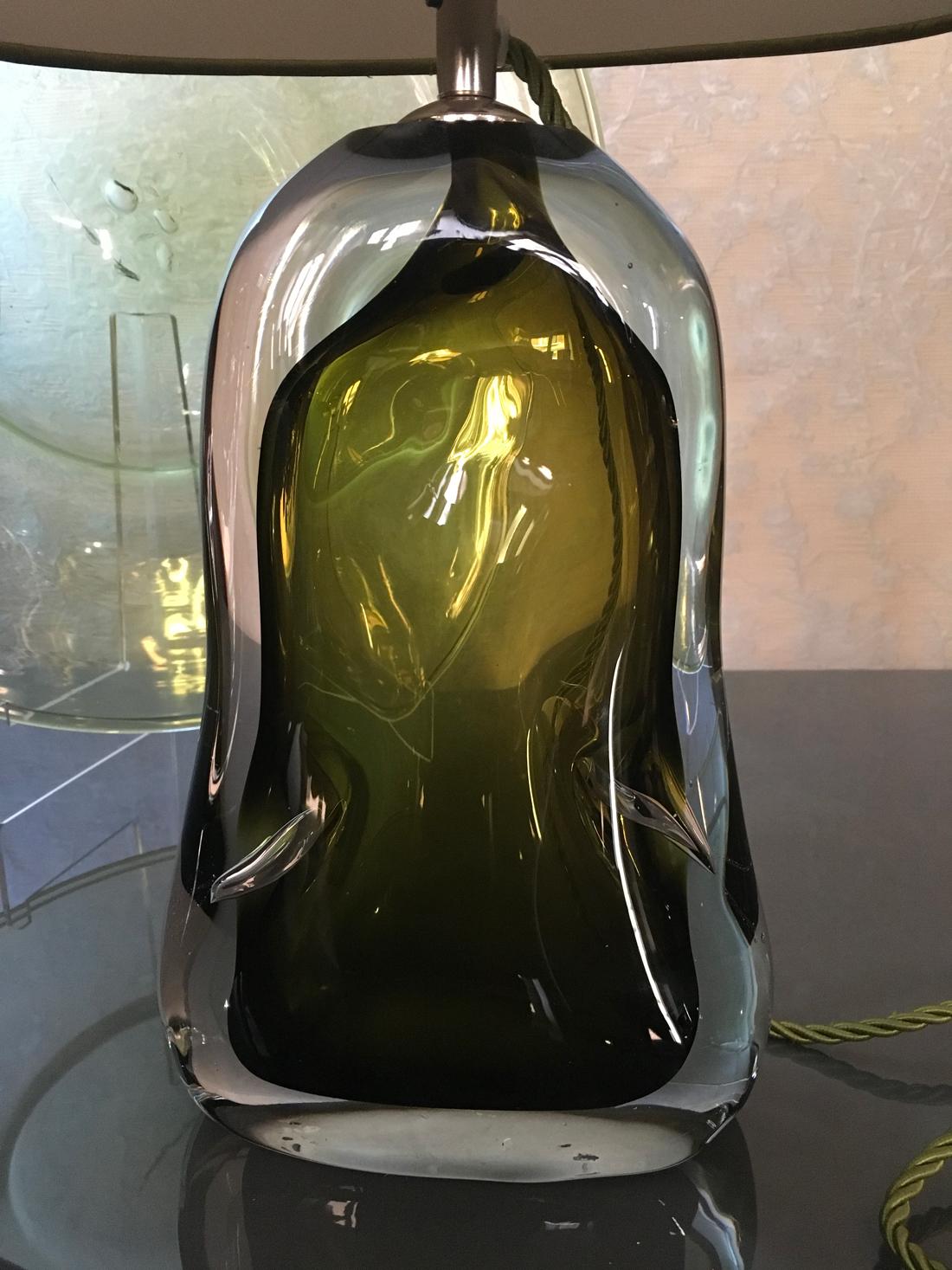 Contemporary green blown glass table lamp.
It is a beautiful eye-catching, an object of art for the solide presence of the handcrafted glass.

Due to the hand made blown glass and the item need to be ordered, the color can be minimun different
