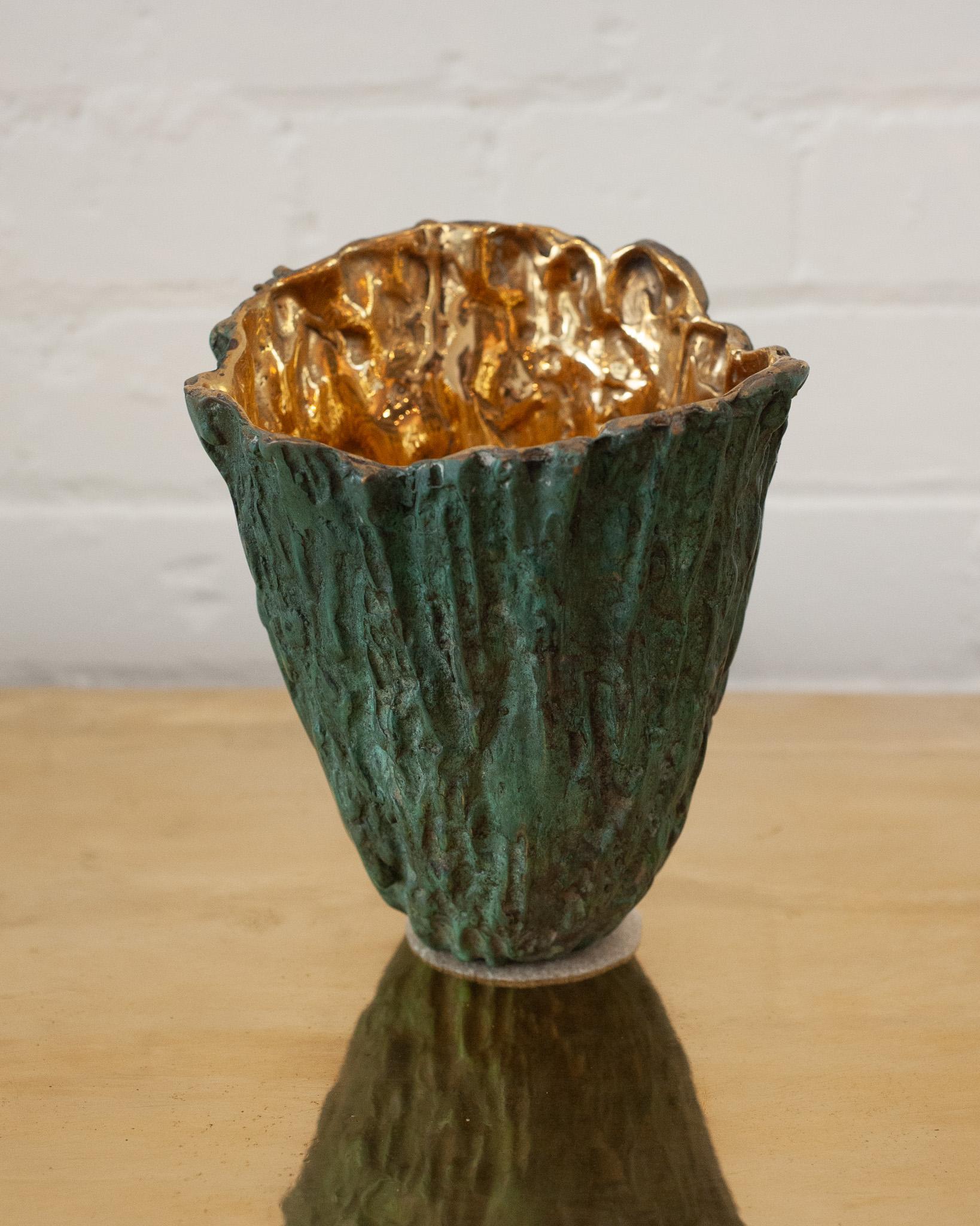 Un dialogo tra natura e metallo - Questo vaso in ottone fuso bilancia una texture di corteccia di legno in una sofisticata patina verde sulla superficie esterna con un interno ad alta lucentezza che cattura e riflette la luce. Queste due finiture di