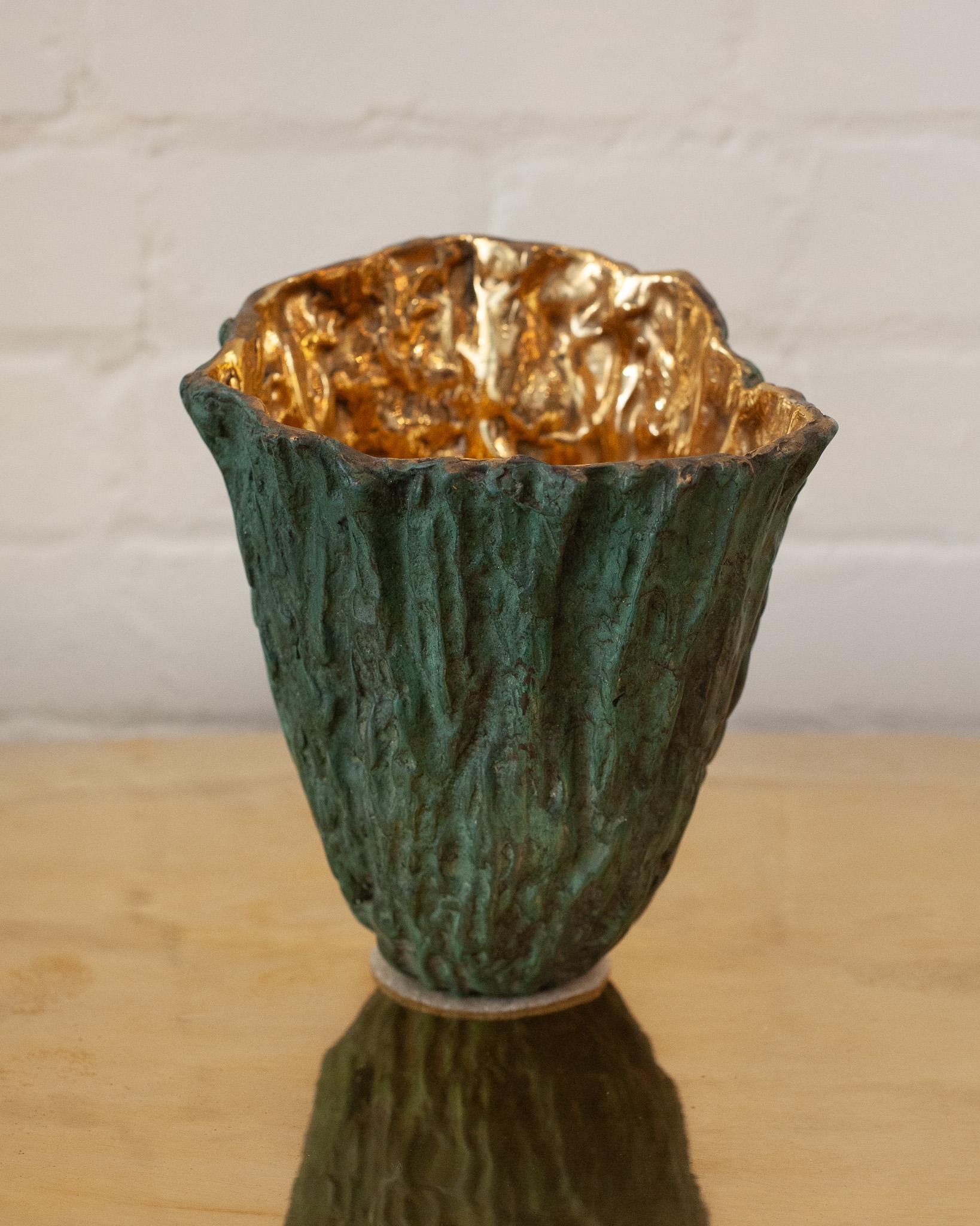 Un dialogo tra natura e metallo - Questo vaso in ottone fuso bilancia una texture di corteccia di legno in una sofisticata patina verde sulla superficie esterna con un interno ad alta lucentezza che cattura e riflette la luce. Queste due finiture di