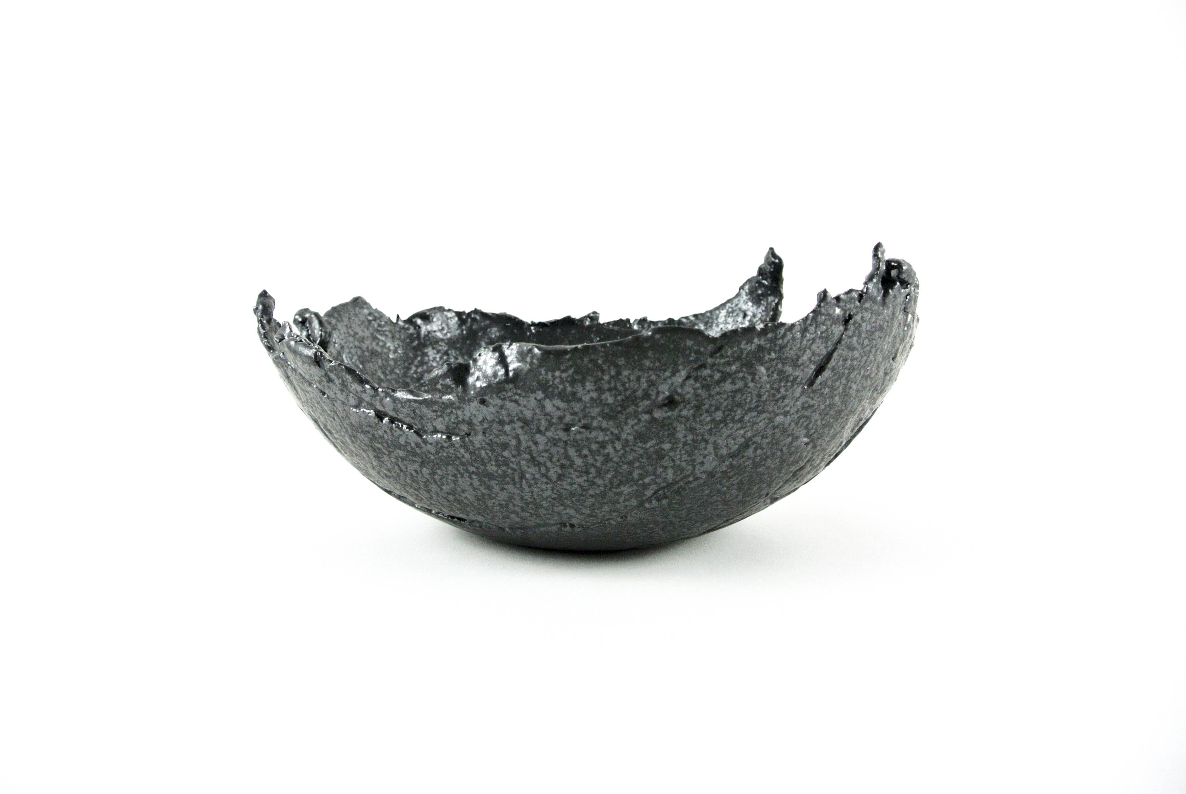Rough grey stoneware bowl with raw and asymmetric edges (ca 32 x 31 x 14cm) and black silvery glaze. Fire sand texture as well as pleats visible on surface.
Functional or for decoration.