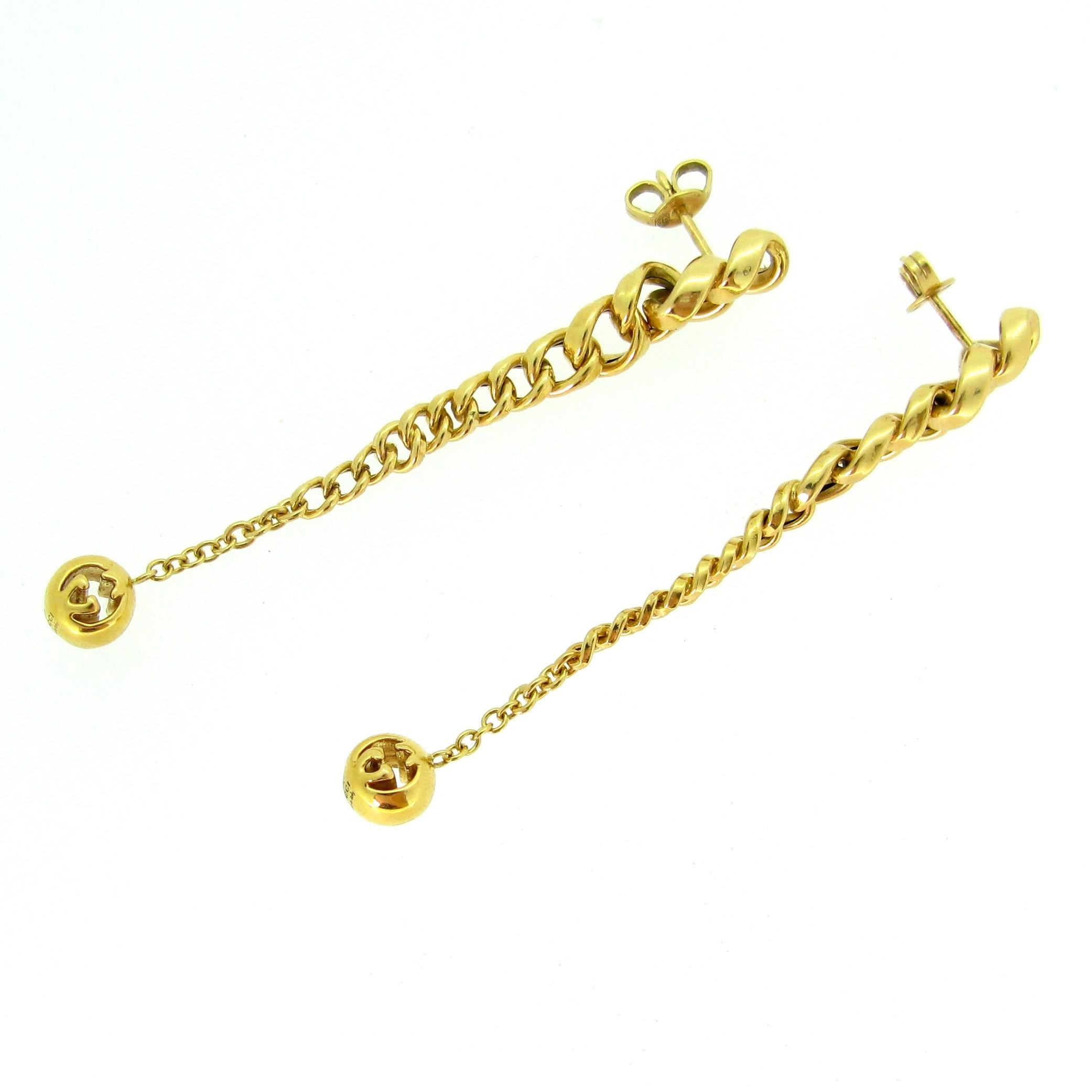 This pair of earrings is signed by the famous Gucci. They are made in 18kt yellow gold. Each earring is made of links forming a long dangling earring – each ball at the bottom shows some cut out work with Gucci’s logo and is signed Gucci