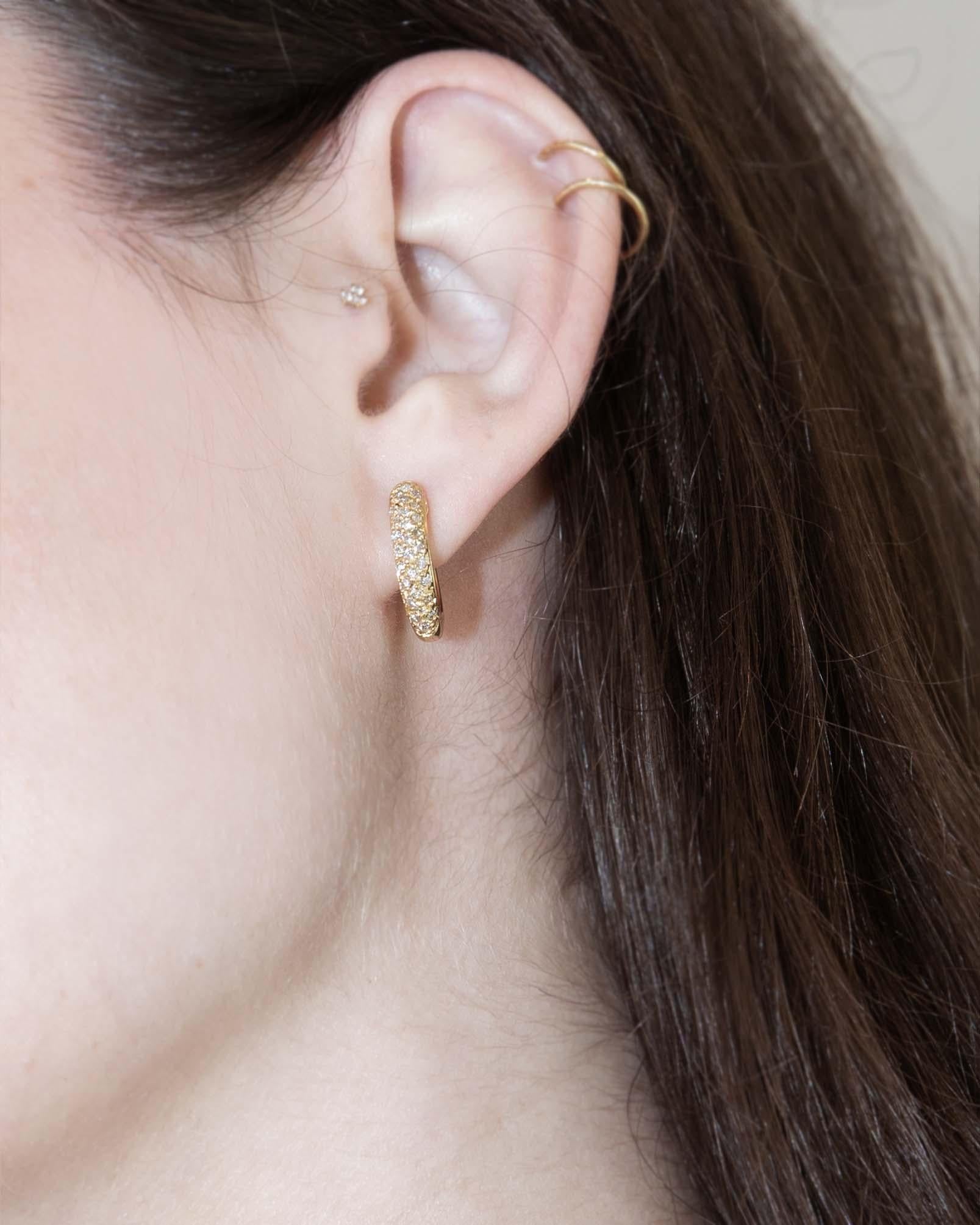 Eleganz mit den Harolin Half Carat Diamond Hoop Earrings, wo 18 Karat Gold wie Sonnenlicht auf ruhigen Gewässern schimmert. Jeder Diamant funkelt mit geflüsterten Geheimnissen und spinnt Geschichten von Liebe und Anmut. Schmücken Sie Ihre Ohren mit