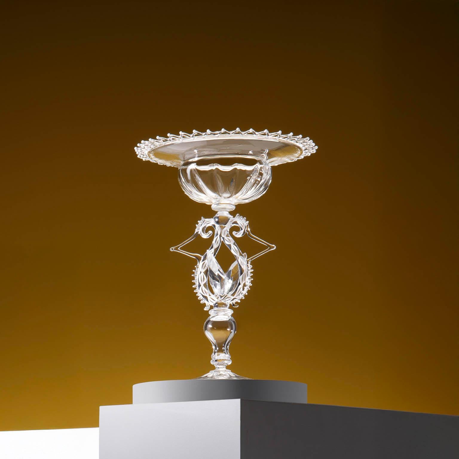 scultura in vetro contemporanea di Simone Crestani
Pezzo unico

Il calice di cristallo di Simone Crestani trasforma le tradizionali forme veneziane in un'esplorazione poetica di eleganza e struttura. Realizzato a mano in vetro soffiato incolore, il