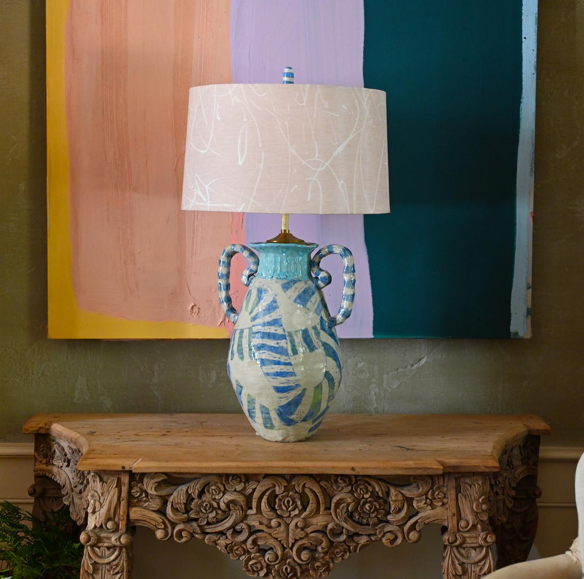 Contemporary ceramic urn form lamp in ivory-beige, medium blue and turquoise. This handled urn-form lamp is patterned in an alternating band of ivory-beige and blue, with occasional flecks of yellow. The arms are similarly striped and the turquoise