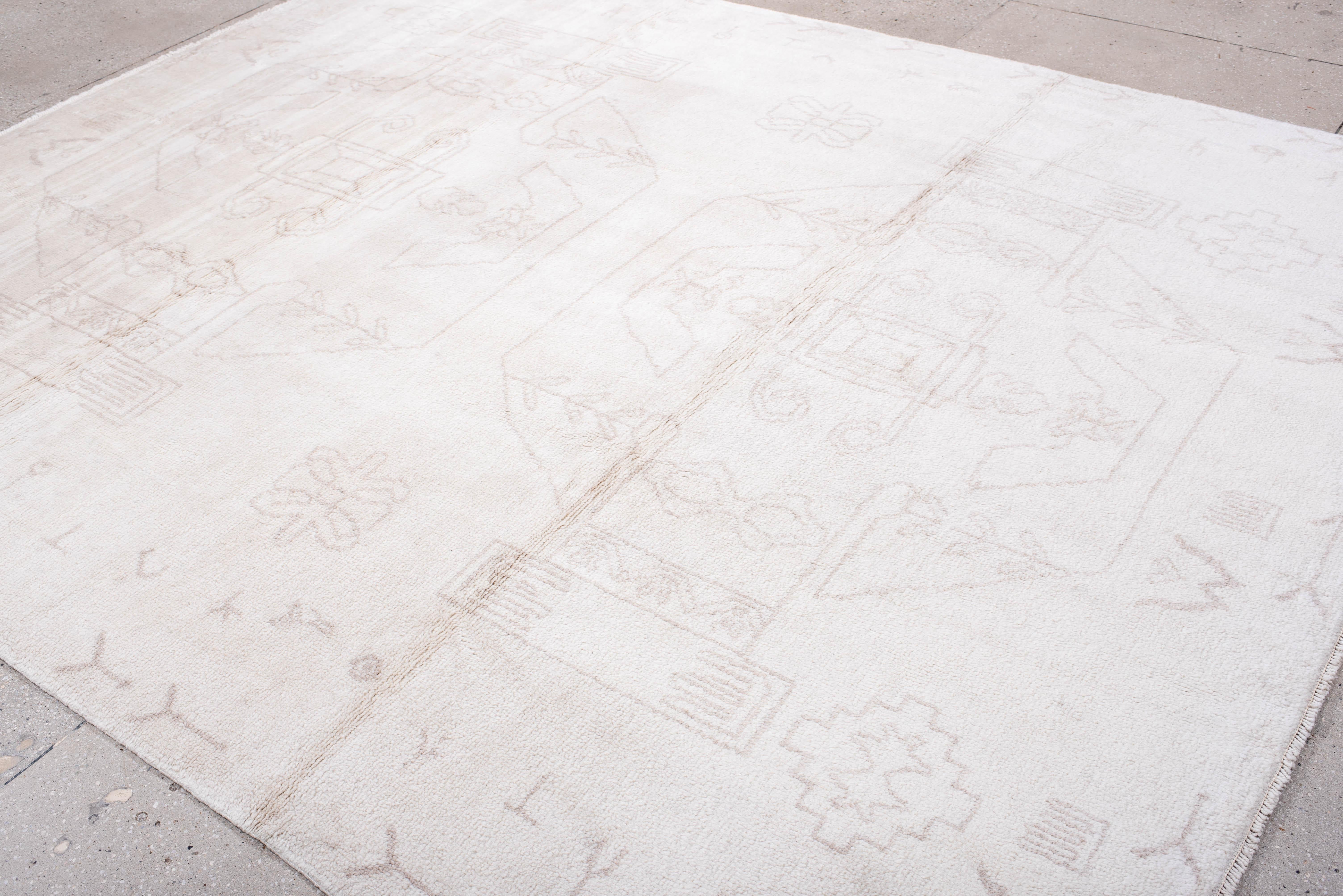 Dieser moderne marokkanische Teppich zeigt schwache Stammes- und architektonische Formen, gewebt aus elfenbeinfarbener Wolle. Die sanfte, aber dennoch grafische Farbpalette und die zarte Linienführung schaffen eine ruhige Grundlage mit