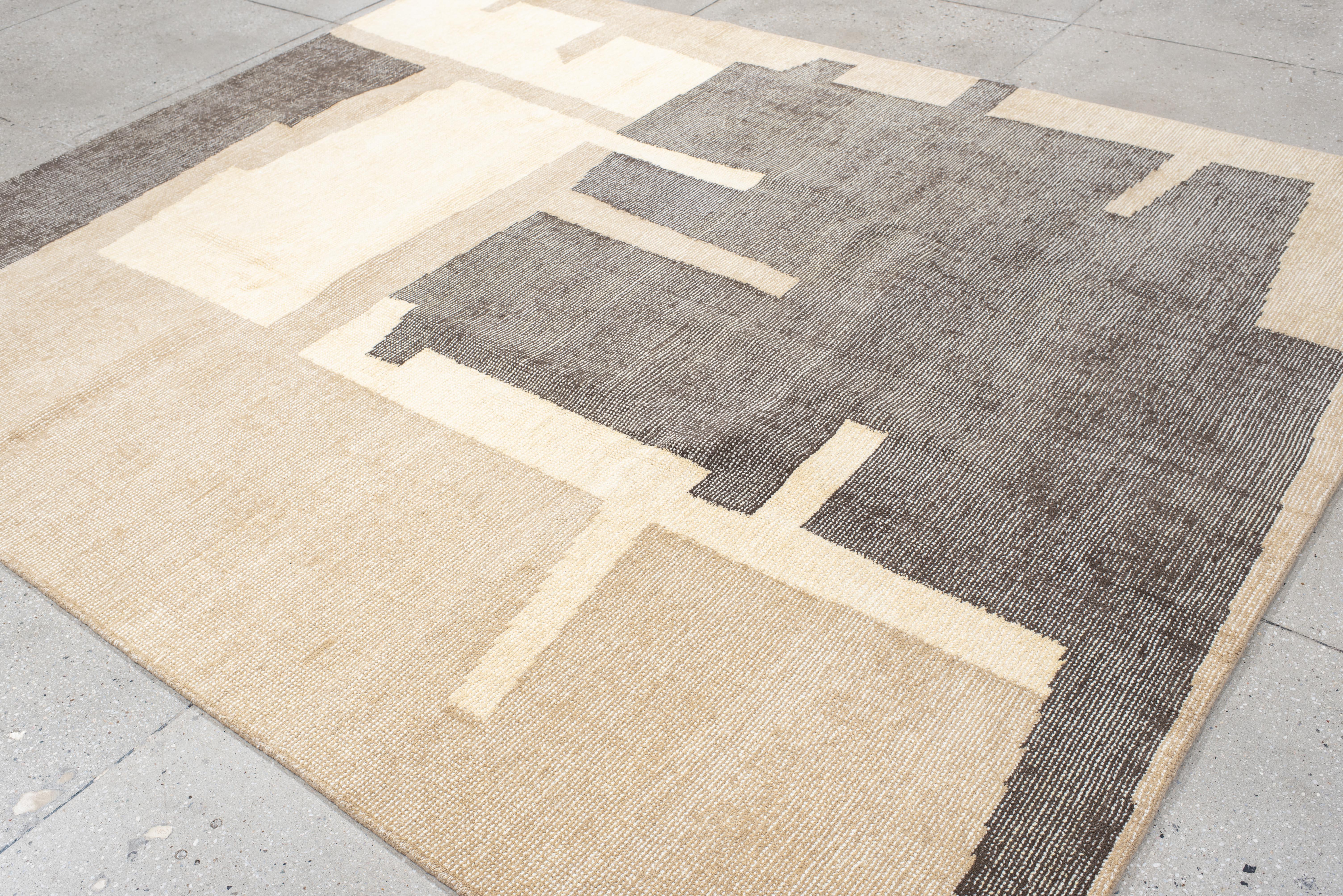 Ce tapis contemporain tissé à la main présente une composition architecturale saisissante de formes imbriquées dans les tons anthracite, beige et ivoire. La disposition géométrique audacieuse évoque les paysages urbains et l'abstraction moderniste,