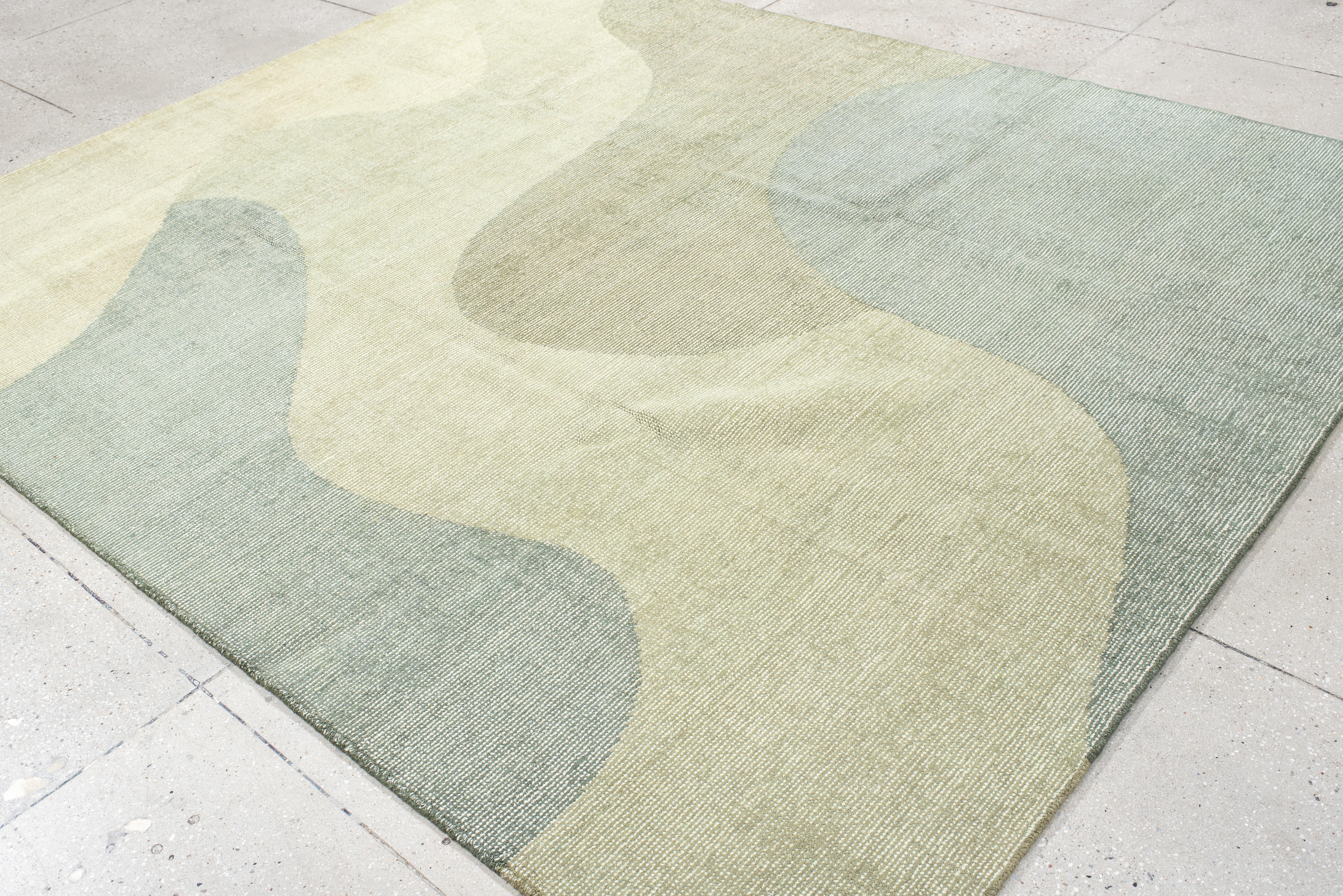 Questo tappeto contemporaneo lavorato a mano presenta un design organico e rilassante con forme fluide simili a quelle di un'ameba nei toni del salvia, del muschio e della pietra. Le curve sottili e la tavolozza armoniosa evocano un'estetica