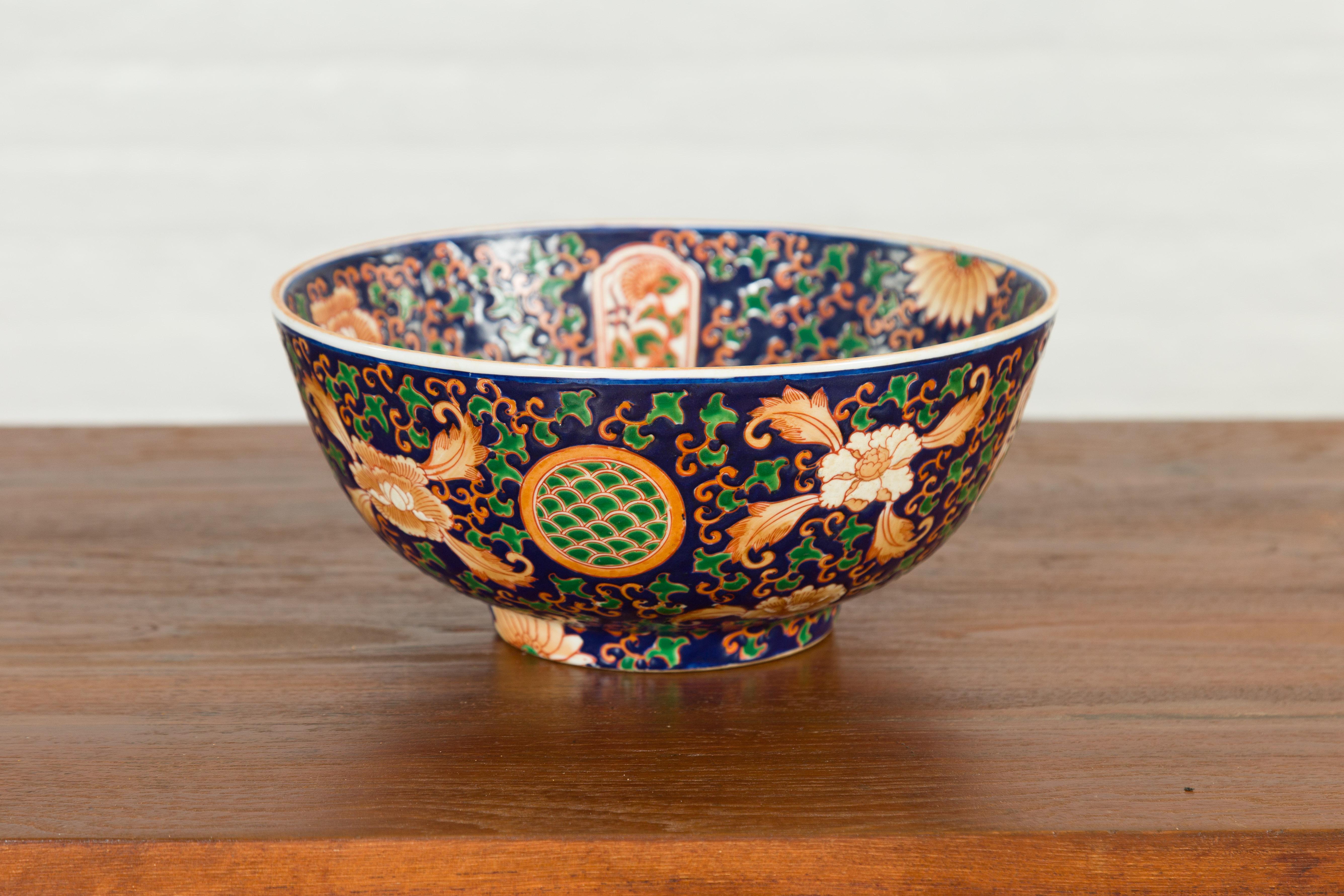 A Chinese contemporary hand painted bowl with cobalt blue ground, green and orange floral decor. Attracting our eyes with its rich motifs, this Chinese hand painted decorative bowl features a cobalt blue ground accented with delicate orange petite