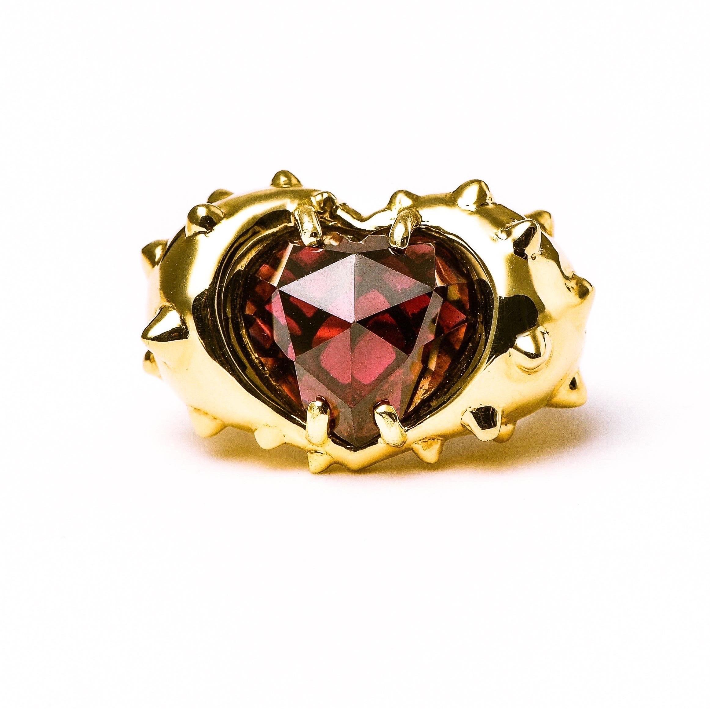 The ‘Spiked Heart’, ring is masterfully hand sculpted and crafted in 18K yellow gold, hallmarked in Cyprus. This impressive, statement ring comes in a highly polished finish and features an 11 Ct heart shaped, rose cut, wine Red Garnet. Red Garnet